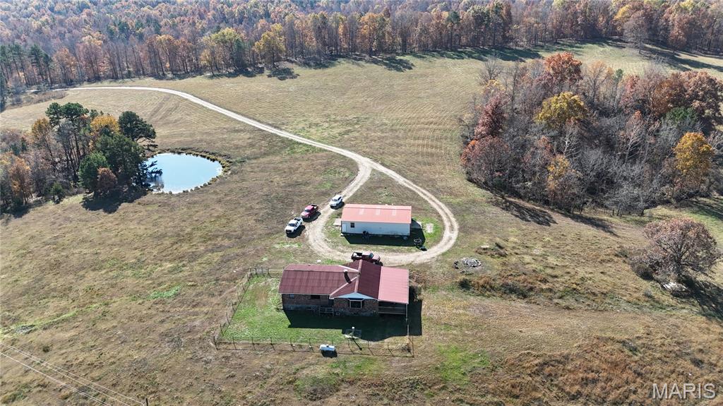 244 acres of pure beauty  surrounds you when you enter this property, the long private drive from the gate to the house is alluring. The House is located near the center of the property with territorial panoramic views, you can look out the windows or from the 33 x 16 covered deck and oversee the majority of your property. This feature is great because this was a working cattle farm for the past 60 + years and if Cattle is your thing you could step right in and start right up. This property is perimeter fenced and cross fenced  with t post and the majority of the H braces at the ends and corners are  constructed of welded metal pipe, all recently done. The pastures are well established and are clear of rock and debris , They also have some of the richest soil in this county with an NCCPI rating of 62.6 on the pasture ground which translates into a nutrient rich hay crop with the possibility of two cuttings dependent on grazing. The average NCCPI rating for Reynolds county is 27.7. There are two deep wells on the property, anti freeze waters , pipe corral panels forming a paddock and chutes a cattle scale and a Priefert brand squeeze chute all included. If Cattle isn't your thing this property lends itself to a peaceful retreat for a full time residence or weekend getaways. the house dates the mid 1980s and is well built, it features a full brick veneer with two full baths and 4 bedrooms the kitchen is large with a  island bar and  separate dinning area, the house is in good condition but could use some updates.  There is a mix of woodlands and pastures with multiple ponds some stocked with fish. The Fishing and Hunting are excellent on this property. this property also lends itself  to horses or other livestock with the pasture quality making it ideal for grazing animals or crops. If you don't want to hang out at the ranch there are many attractions nearby including the Black river, Johnson shut ins state park, the Current River Conservation area and Clear Water Lake just to name a few. whether this will be a full time residence or a weekend getaway this place is truly a piece of paradise. make an appointment and come check it out, it will not disappoint. for those that wish to stay connected a  fiber optic internet connection was just installed in the residence may 2026. also see MLS listing for an additional  228 acres 1/4 mile away (still in view of main farm)