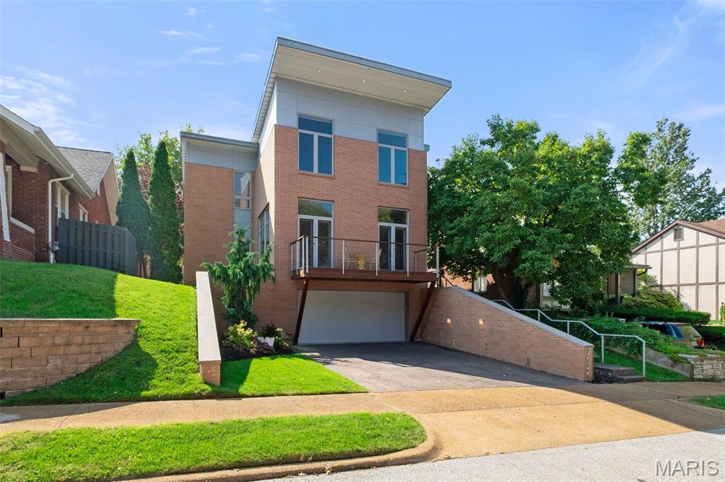 Sophisticated and rare, this contemporary all-brick home delivers the style and function so hard to find in St. Louis. Designed for modern living, it features soaring 10’ ceilings, job-finished maple floors, expansive windows, electric fireplace, and an effortless open plan just a couple of blocks from Clayton. The professionally outfitted chef’s kitchen with dual Caesarstone islands, top-tier Gaggenau gas cooktop (with island hood), dual Monogram ovens, Thermador 48" refrigerator, and an oversized walk-in pantry. Retreat to a vaulted primary suite with spa-worthy marble bath, dual Duravit vanities, soaking tub, separate shower, and two walk-in closets. 2 additional bedrooms, hall bath & washer and dryer on 2nd floor. A finished lower level offers a guest suite with a Murphy bed and full bath, while the backyard—with gas outdoor fireplace—sets the scene for entertaining. Two-car garage. A true work-live-play location completes this modern lifestyle.