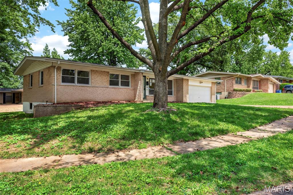 Fully renovated 5-bedroom, 3-bath ranch in Florissant, offering nearly 2,000 square feet of finished living space across two complete levels, ideal for multigenerational households, guests, or flexible home office needs. The main level features three bedrooms, refinished hardwood floors, an updated tuxedo-style kitchen with quartz countertops, stainless steel appliances, and pantry storage, plus a heated and cooled four-season room overlooking the backyard. The finished walkout basement adds two legal bedrooms, a full bath with walk-in shower, laundry area, and LVP flooring and a self-contained living suite accessible from both inside the home and the backyard. New electrical service, fresh neutral paint, and a passed City of Florissant occupancy inspection make this home move-in ready with no deferred maintenance. Located within walking distance of Walnut Grove Elementary, minutes from Highway 270, St. Louis Community College Florissant Valley, Lambert International Airport, and a full corridor of shopping and dining along New Halls Ferry Road.
