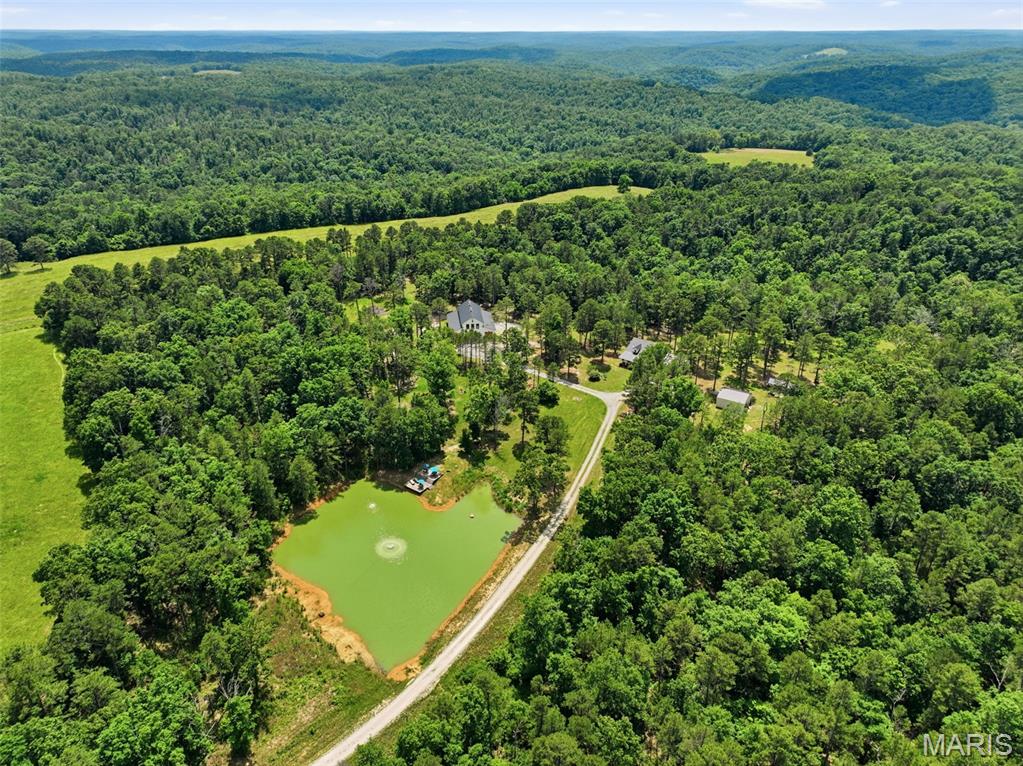 The Pigeon Farm
A turnkey 137-acre Ozark estate near Montauk, MO featuring a main residence, a luxury 60'x40' living barn, and a private Ozark-pine log cabin on its own 22-acre parcel. Stock pond, commercial greenhouse.

Overview
Welcome to the ultimate turnkey country estate, where luxury meets uncompromised rural freedom. Sprawling across 137 pristine acres minutes away from the historic Montauk area, this exceptional property offers a rare combination of three distinct living structures with not a single shortcut made when designing this dreamy retreat. The owners did not miss a single detail

Tucked away off of a blacktop road, you will drive into a secluded driveway that leads up to a breathtaking property. A beautiful house, a barndominium, and a well-maintained stock pond await you at the top of the hill, while the log cabin sits privately on the other side of the property. Whether you are seeking a private multi-generational family compound, a high-end corporate retreat, or a premier income-producing homestead, this estate transfers completely finished and fully equipped to let you step right into the life you've been dreaming of.

The Main Residence

The heart of the daily operation is a warm, inviting 3-bedroom, 2-bathroom home featuring a dedicated private office—ideal for managing the property or working remotely.  The interior features accents and historic reclaimed flooring sourced directly from Ohio.  Surrounded by mature trees and manicured green space, it offers the perfect balance of quiet privacy and central accessibility to the rest of the farm's world-class amenities.

The Showstopper: Executive Living Barn

No expense was spared in the construction of this magnificent 60'x40' architectural masterpiece. The building seamlessly blends heavy-duty utility with high-end luxury:

The Upper Level: A breathtaking, completely finished 1,250 sq. ft. luxury residence. 

The Kitchen & Living Space: Enjoy a fully equipped master kitchen designed for entertaining. The entire upper level comes fully furnished with premium interior pieces.

Climate & Mechanicals: Stay perfectly comfortable year-round with separate, dedicated HVAC systems servicing the upstairs and downstairs independently. The lower shop area features heavy-duty, commercial-grade automatic garage door openers for seamless equipment access.

The Private Green Cabin

Tucked away on its own 22-acre sub-parcel sits a stunning 20'x40' guest cabin built entirely out of local Ozark pine. Rich with history, this all-wooden structure serves as a highly lucrative guest rental option or an unforgettable, private escape for visitors:

Layout: 2 Bedrooms, 1 Bathroom, and an expansive character loft upstairs.

Artisanal Craftsmanship: Built entirely from local Ozark pine, the centerpiece of the cabin is a magnificent, floor-to-ceiling stone fireplace featuring native stone harvested directly from the farm's acreage.

Turnkey Ready: This cabin conveys completely furnished and features its own independently checked, fully operational well system.

The Land: 137 total acres of beautiful Missouri terrain, divided into a 115-acre main farm tract and the 22-acre cabin parcel.

Commercial Greenhouse: A professional-grade greenhouse setup, completely outfitted with its own dedicated water pump, electricity, and automated ventilation fans—perfect for year-round homestead production or commercial cultivation.

Modern Waste System: A highly efficient, 3-year-old septic system cleanly services the estate, utilizing a smart "party line" layout that integrates the main house and the barn structures seamlessly.

Water Security: A high-producing shared well anchors the main house and barn, while the cabin enjoys its own separate, verified water source.

Properties of this scale, caliber, and complete turnkey readiness are an absolute rarity. Schedule your private tour of this magnificent estate today and secure your piece of pure Missouri freedom.