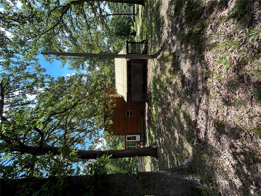 Rare opportunity to own nearly 34 acres in one of the Lake area's most sought-after recreational settings! Located just minutes from the State Park, Swinging Bridges, and the Grand Glaize Arm of the Lake, this 3-bedroom, 2-bath home offers 1,776 square feet and the chance to build instant equity. Whether you're searching for your next investment, hunting retreat, hobby farm, or private country escape, the possibilities are endless. The partially fenced and cross-fenced acreage is perfect for horses, livestock, or outdoor recreation and is teeming with wildlife. Property improvements include an inviting wraparound porch, cozy three-season room, permanent chicken coop with water and electric, RV carport, and a spacious workshop with room for boats, ATVs, tractors, or equipment. Bring your vision and a little elbow grease to unlock this property's full potential. Selling AS-IS, this is an outstanding opportunity to create something truly special.