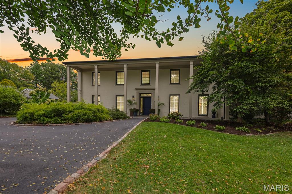 Nestled on nearly an acre in Ladue's most enchanting storybook neighborhood, 29 Picardy Lane represents a rare opportunity to enjoy refined living in a setting defined by wide lawns, open green spaces, and a canopy of mature trees all within walking distance to the Conway Elementary. This stately two-story Colonial, with its columned facade offers timeless curb appeal and a sense of arrival that is both elegant and welcoming. Inside, the home artfully balances architectural tradition with sophisticated updates. The formal dining room exudes character with hardwood floors and designer lighting, an ideal backdrop for both intimate dinners and larger gatherings. The first-floor office, anchored by a handsome fireplace, provides a serene retreat for work or study, while the reimagined kitchen and adjoining family room reflect today's preference for open, light-filled spaces. Expansive windows and doors blur the boundary between indoors and out, creating a seamless flow for entertaining or simply enjoying the natural beauty of the grounds. Upstairs, the expansive primary suite is a true sanctuary, featuring a vaulted ceiling, stylishly appointed bath, and generous storage. Two additional bedrooms, each with a dedicated en-suite bath, provide comfort and privacy, ideal for family, guests, or multi-generational living. This home embodies the lifestyle for which Ladue is known: elegant, functional, and enduring.