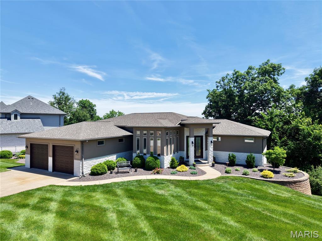 Perched above the Mississippi River with sweeping panoramic views, this stunning atrium-style ranch home offers an extraordinary blend of architectural grace and thoughtful living. Spanning over 3,400 square feet on 1.51 private acres, soaring ceilings bathe the interiors in natural light. Four bedrooms include two luxurious primary suites one conveniently located on the main level, and a second retreat in the finished lower level, ideal for multigenerational living. The heart of the home features a luxurious chefs kitchen, a striking gas fireplace with a custom stone surround, while the south-facing sitting room has been appointed with new windows . Downstairs, a fully equipped kitchenette 3 total bedrooms with egress windows and a large storage room with double exterior doors offer versatile utility, a hobby space, or lawn and equipment storage. Thoughtfully landscaped grounds complete this rare offering.