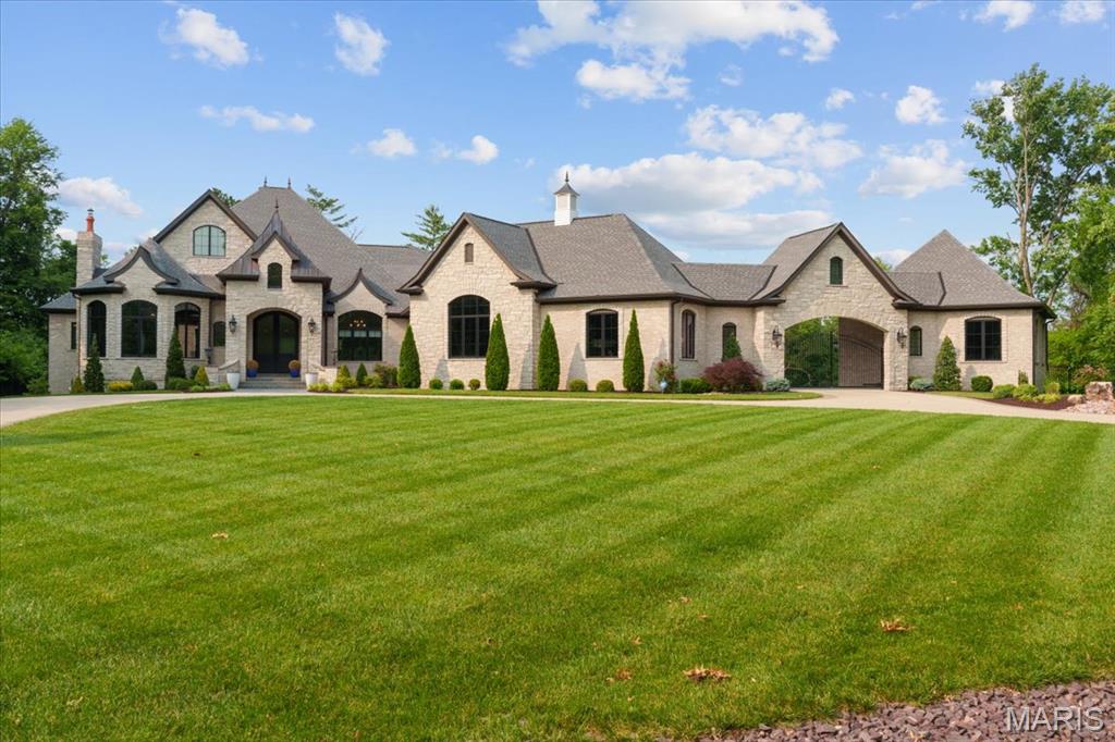 Nestled on a private 2.36-acre lot, this meticulously crafted home by Bozich Construction offers unparalleled luxury and sophisticated living. With 4 fireplaces, an expansive 5-car garage with porte-cochere, and an impressive layout, every detail has been thoughtfully designed to elevate your lifestyle, while still making you feel "at home". Upon entering, you’re greeted by a stately study featuring a coffered ceiling, setting the tone for the exquisite finishes throughout. The functional yet stylish kitchen is equipped with professional-grade appliances, an expansive island, and a spacious butler’s pantry with additional appliances. The home offers multiple living spaces, including a sunroom with wood-burning fireplace and a screened-in porch. The expansive master suite is a true retreat, complete with a sitting room, two walk-in closets, and a luxurious en-suite bath. Two additional ensuites are located on the main level, while the fourth ensuite upstairs includes its own private laundry room and the potential to add a fifth bedroom. The finished lower level, perfect for entertaining, includes a gorgeous wet bar, home gym, and additional full and half baths. Floor-to-ceiling sliding doors open to the stunning outdoor area, which features a saltwater pool, patio fireplace, and plenty of space for outdoor activities.