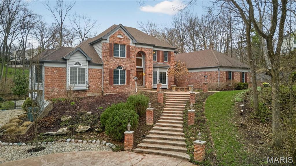 Situated on a private 1.8-acre lot backing to trees, this stately 1.5-story home offers an exceptional setting with remarkable outdoor living, including a private in-ground pool with hot tub and waterfall, fenced yard, circle driveway, and 4-car side-entry garage. The expansive grounds provide rare privacy and space, ideal for entertaining, relaxing, or enjoying the peaceful surroundings. A grand 2-story foyer welcomes you, flanked by a formal dining room and a private study with boxed beam ceiling, built-ins, and French doors. The 2-story great room offers a gas fireplace and walk-up wet bar, while the generous kitchen includes 42" cabinetry, center island, double ovens, gas cooktop, and adjoining breakfast room with access to the composite deck. The vaulted hearth room showcases beamed ceiling and wood-burning fireplace, adding warmth and character to the main living area. The main-level primary suite offers a coffered ceiling, bay window, large walk-in closet plus additional closet, and a spacious bath with double vanities, jetted tub, separate shower, and private commode room. The upper level includes three bedrooms, with one private bath and a Jack-and-Jill bath. The finished walk-out lower level provides an expansive rec room with fireplace, walk-behind wet bar, exercise room, two additional bedrooms, and full bath. Main-level laundry, circle drive, and extensive outdoor living areas add to the home’s appeal. Property to be sold in as-is condition, presenting a wonderful opportunity for the next owner to bring their own vision and personal style to an already impressive home and setting.