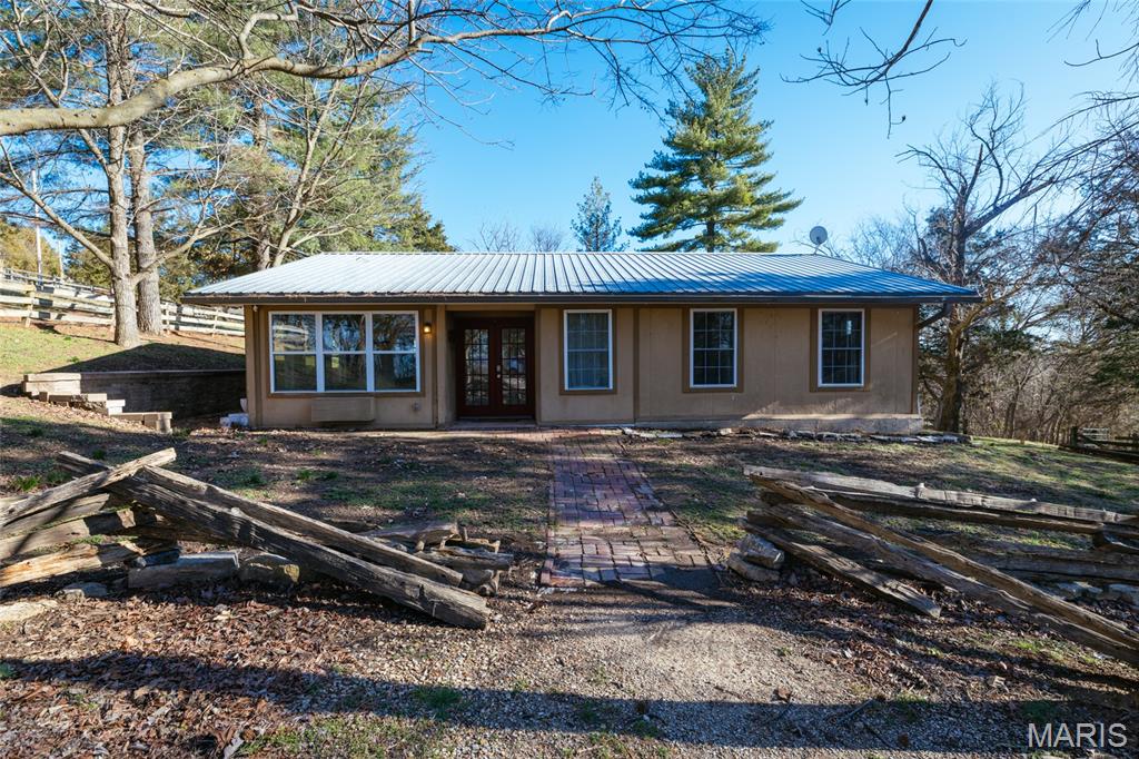 Short term tenant in the home please wait for confirmation to show......Check out this beautiful farm on over 5 acres featuring a lovely rustic ranch home and two outbuildings, plus fenced in pastures. This 2,526 sq ft home has some wood flooring and stunning wood ceilings. You will find a beautiful historic log cabin section with a lovely brick fireplace. Nice large bedrooms and beautiful finishes throughout. The first of the outbuildings is 24x54, has water and electric, and has potential for 3-4 stalls which would be great for farm animals like horses, chickens, goats, or whatever you please! It also has sliding doors on each side so you can let the air flow through! The second one is 24x36 could be used as a workshop, storage, or machinary work, etc. It also has water and electric, plus it is insulated! On this farm you will find fenced in pastures and a pond. Only minutes to Labadie where you'll find amazing restaurants, and just a few more to Washington and Wildwood where you'll find plenty to do!