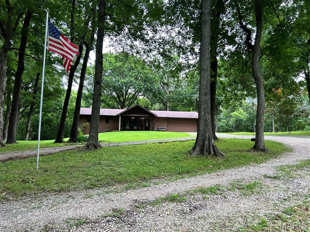 Mini farm potential on 5 scenic acres in Jackson with no HOA! This raised ranch offers 3 bedrooms, 3 bathrooms, plus a bonus room and walk-out basement. Main level features hardwood floors, wood-burning fireplace, attached 2-car garage, and spacious kitchen/living spaces. Primary suite includes walk-in closet, en suite bath, and private access to the large back deck overlooking mature trees. Lower level includes 1 bedroom, 1 bathroom, bonus room, John Deere room, and walk-out access. Immediate backyard is fenced with chain link. Property includes multiple outbuildings including a 21’x30’ pole barn, 14’x32’ insulated shed, fenced livestock area with structure, and old chicken coop. Previously used as a mini farm. Peaceful setting with room to spread out while still being conveniently located near Jackson amenities.