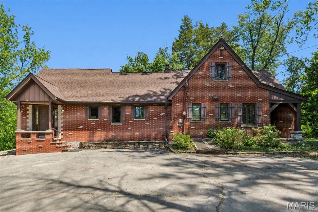 This property has much to offer for a homeowner looking for privacy and yet still close to the amenities of every day life.  Also perfect for the home based business person.  Private drive leads you through 10+ beautiful acres of grassy areas and woods with two ponds to the large main brick home and separate studio home / office, 3 garages (7 bays total) and garden shed.  The main home is a spacious 3 bedroom, 2 bath, 1.5 story with luxury upgrades and old world charm.  Huge vaulted family room with beautiful oak woodwork, arched window with window bench, French doors opening to large deck, plus hidden pet door built into the custom cabinetry.  The kitchen offers high end Sub-Zero refrigerator, Thermador induction range with hood, built-in convection oven and microwave.  Stainless steel countertops with tile backsplash and marble splash guard. Leaded glass cabinets and luxury plank tile flooring.  Grand hallway leads to formal dining room, main level bedroom, bathroom and sunken living room with beamed ceiling, wood burning fireplace, built-in book shelves overlooking covered patio, pond and woods.  Full bath and two additional bedroom with plenty of closet space on the upper level.  Full basement with partial finished area.  Zoned heating; separate furnace and electric panel for the family room additional.  Additional features of the main house includes central vac, new roof, Leaf Filter guttering and new deck.  The studio home has full kitchen with breakfast bar, large living room also with a custom pet door, built in retro stereo system, loft area / crows nest with windows over looking the property and sliding doors to cover porch.  The property also has a tool / garden shed and 3 separate garages.  A 3 bay garage, a 2nd 3 bay heated garage with work bench and loft, plus a single car garage.  All this located on 10 plus private acres with two ponds and a shooting range hut.  The beauty of the land can be enjoyed from the new deck or the large covered patio over looking the acres.  Concrete plunge pool waiting to be restored to its glory.  Offering in current as is condition.  Seller will not make any repairs or provide inspections.