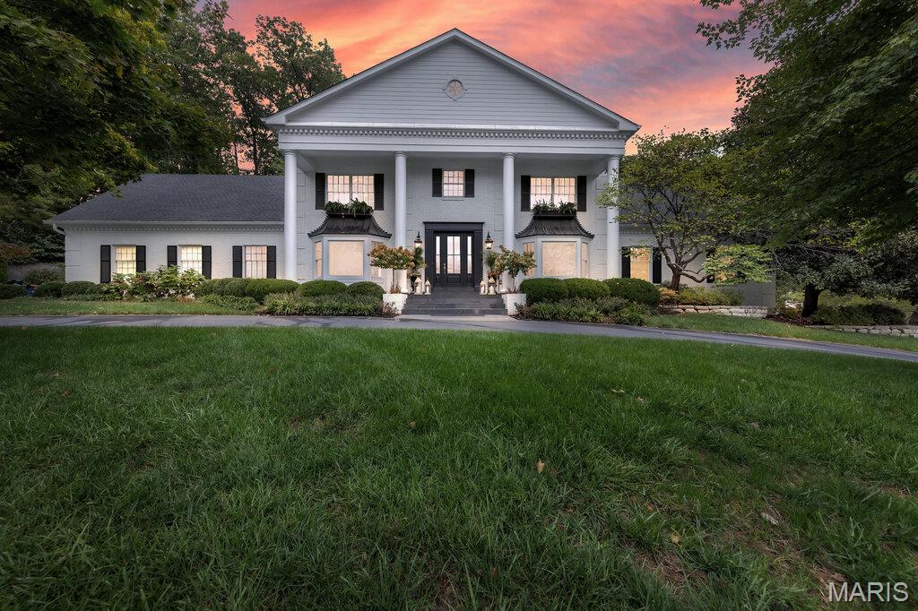 Nestled on a picturesque, tree-lined cul-de-sac in the prestigious Weston Place neighborhood of Town & Country, this stately, updated Georgian Colonial offers timeless elegance, exceptional craftsmanship, and over 6,000 square feet of beautifully finished living space. Designed with sophistication and comfort in mind, this five-bedroom, six-bath residence sits on nearly an acre of manicured grounds, offering both privacy and convenience in one of St. Louis’ most desirable communities.  From the moment you arrive, the home’s classic brick façade, columned portico, and lush landscaping set the tone for what awaits inside. The grand two-story foyer welcomes you with gleaming hardwood floors, intricate millwork, and a sweeping staircase. Off the foyer, formal living and dining rooms offer the perfect spaces for entertaining, each featuring tall windows, crown molding, and refined architectural details that speak to the home’s timeless design.
The heart of the home is the newly remodeled expansive kitchen and hearth area, designed for both daily living and large gatherings. The chef’s kitchen boasts white cabinetry, quartzite countertops, two refrigerators, stainless steel appliances, a center island, and a spacious breakfast room overlooking the serene backyard. Adjacent to the kitchen, the inviting family room features a brick fireplace, wet bar, and custom built-ins—creating a warm, comfortable atmosphere ideal for family time or entertaining guests. French doors open to a bright covered porch and paver patio, where you can relax and enjoy the peaceful, park-like setting. A convenient main-level laundry room and butler’s pantry with sink and additional dishwasher and two half baths complete the main floor. Main Level luxurious primary suite serves as a retreat, featuring a generous bedroom  2 walk-in closets , and a spa-inspired marble bath with double vanities, soaking tub, and steam shower. Four additional bedrooms are located on the upper level, each with access to updated baths, including a Jack-and-Jill arrangement perfect for family living.
The finished lower level adds more living and entertaining options, including a large recreation room, fireplace, wet bar, exercise area, full bath, and abundant storage space. Whether used for entertaining, hobbies, or a guest suite, the lower level provides flexibility to meet any need.
Outside, the professionally landscaped one-acre lot offers multiple gathering areas, including a brick patio with fireplace, level lawn, and mature trees that provide both beauty and privacy. The three-car side-entry garage, circle drive, and elegant exterior lighting enhance the property’s impressive curb appeal.
Additional features include a 5-year-old roof, updated HVAC systems, irrigation, and security systems. The home has been meticulously maintained and thoughtfully improved over the years, offering peace of mind for its next owners. Located in the award-winning Mason Ridge- Parkway West School District, the location provides convenient access to shopping, restaurants, hospitals, and major highways—while still preserving the peaceful, upscale ambiance that defines Town & Country living.
With its blend of classic architecture, generous space, and modern amenities, this remarkable property offers the best of St. Louis luxury living. From elegant entertaining to relaxed family gatherings, every space has been designed with comfort, quality, and grace in mind. Don’t miss this rare opportunity to own a home of distinction in one of the area’s most sought-after neighborhoods.