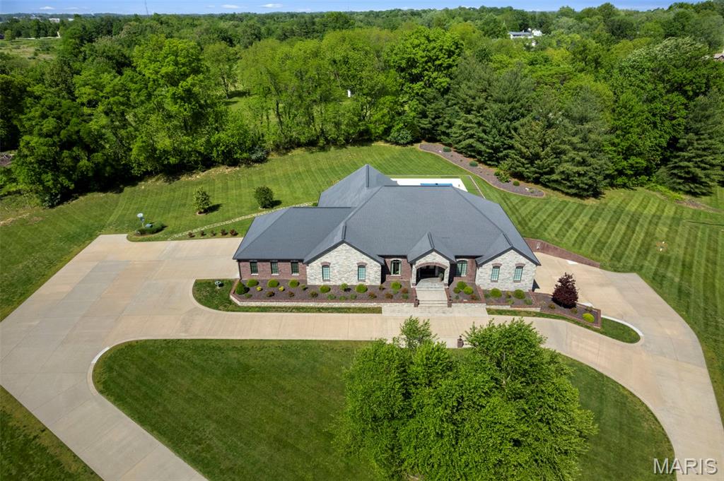 Nestled on 10 +/- breathtaking acres on the edge of Jackson within an exclusive subdivision setting, this extraordinary all-brick estate offers a rare blend of luxury, privacy, and timeless elegance. Surrounded by mature trees and beautifully established landscaping, the property creates a secluded, park-like setting just minutes from town conveniences.

Offering nearly 8,000 square feet of finished living space plus approximately 1900 square feet of unfinished space for storage or future expansion, this remarkable residence features 5 bedrooms, a 6th non-conforming bedroom or flex room, and 4 1/2 luxurious bathrooms. Grand entertaining spaces, soaring tray, vaulted, coffered, and volume ceilings, extensive custom crown molding and millwork, and expansive walls ideal for fine art displays elevate the home’s sophisticated design.

Custom cabinetry with soft-close doors and drawers, pull-out storage features, stunning light-catching stone countertops, specially designed sink basins, LED lighting, and designer light fixtures showcase the exceptional craftsmanship found throughout the home. Oversized windows flood the residence with natural light while capturing serene views of the surrounding acreage. A grand main-level office makes working from home effortless, while the private elevator provides convenient access between levels whenever stairs are not an option.

The property also offers exceptional garage and storage accommodations including a 3-car main-level garage and an additional tandem lower-level garage with its own private driveway, making the lower level ideal for guest quarters or multi-generational living.

Outdoors, enjoy your own private resort featuring a spectacular 22x44 heated and cooled saltwater pool complete with expansive concrete decking, built-in benches, elegant glass tile, a premium Bahia shelf, automatic cover, and stunning water features. A 24x24 concrete pad with a water line already ran for a future pool house creates the perfect opportunity for additional entertaining or guest accommodations.

Rarely does a property of this caliber become available. For additional details or to arrange your private tour, please reach out — we would be honored to assist you.
