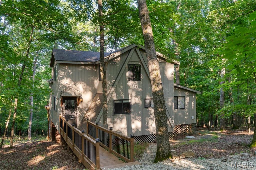 Whether you’re expanding your short term rental portfolio, searching for a peaceful vacation home, or dreaming of full time resort-style living, this turnkey chalet checks every box. Tucked inside the gates of Innsbrook Resort just an hour from St. Louis 2506 Alpine Woods Dr offers rustic charm, modern comforts, & unbeatable access to nature, recreation, & relaxation. Inside, you’ll find 18 ft vaulted ceilings, rich wood floors,& a dramatic floor to ceiling bay window that fills the living space w/natural light. A cozy woodburning fireplace anchors the rm, while direct access to the 4 seasons rm & private deck makes this an ideal gathering spot year round. The kitchen exudes warmth w/its natural wood tones & thoughtful layout. The expansive eat in peninsula offers the perfect spot for everything from breakfast w/ the family to evening wine w/ friends. The main floor primary suite features hardwood floors, vaulted ceilings, dual closets,& private access to the 4 seasons rm. The en suite bath includes a walkin shower & comfort height vanity. 2 addl bedrms, loft & full bath offer flexible sleeping arrangements for guests or family. Step outside to soak in the hot tub, take in the wooded views, or explore Innsbrook’s lakes, golf course, trails, pools & more. Located just steps from the resort’s largest 236 acre Alpine Lake this chalet offers easy access to swimming, fishing, & paddling. With a strong rental history & resort style amenities, it’s a rare opportunity for any buyer.
