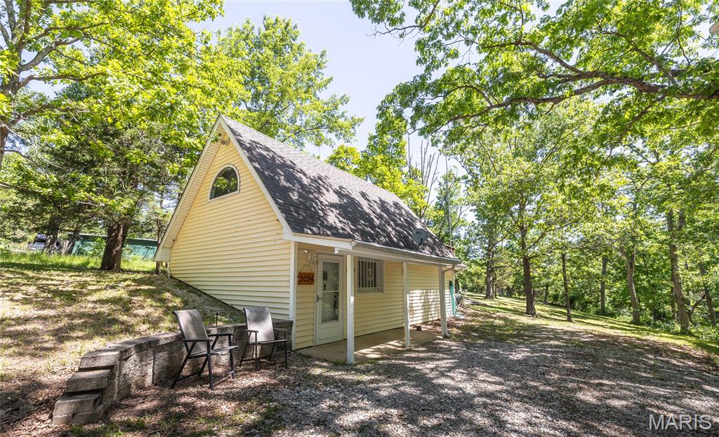 Looking for a place to get away? THIS could be the perfect place for you. Adorable bungalow that is freshly painted and ready for you to move in! Furniture is included! The open plan living area includes kitchen/living space. Also on the main floor is a laundry room and full bath. Upstairs is a cozy loft bedroom, with access to the deck overlooking the wooded lot. This is a double lot and includes a shed and a fire pit. Location is close to cove 9 so you can easily get to a boat launch and the WATER. This home is private so it is a true get away. When you are ready to see people, you are close to the marina and the community center for all the events at the community! Various events are hosted throughout the year including poker runs, potlucks, trivia nights, bingo, beach party with DJ and food trucks, just to name a few things. Indian Lake is a 326 acre +/- lake for all the watersports - fishing, swimming, boating, skiing, tubing and jet skis. The community has pickleball/tennis courts, basketball court and a community center that is home to many events. It can also be rented for a private event. There is a sandy beach with playground and pavilions for members to use and the association has several day use docks available throughout the community at no charge. Annual slip rentals are available through the association or the marina. A full service marina with general store rounds out the community and helps make lake life easy! Road assessment is paid in full for the buyer!