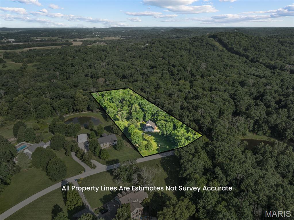 Welcome home to the perfect blend of peaceful country living and modern comfort! Nestled on 4.18 scenic acres in the highly sought-after Washington School District, this impressive 4-bedroom, 3 full bath, 1.5-story home offers privacy, space, and breathtaking views of a neighboring lake—all while providing the convenience of a move-in ready home with extensive updates.

Step inside to an inviting open-concept floor plan featuring luxury vinyl plank flooring throughout the main living areas and a stunning shiplap feature wall showcasing a cozy electric fireplace. Take in serene views with all the living room windows letting in natural light. The spacious kitchen is designed for both everyday living and entertaining with a center island offering seating, double sink, dedicated coffee bar station, abundant cabinetry, and easy access to the expansive 40-foot composite deck overlooking the picturesque countryside.

The oversized primary suite is a true retreat with a large walk-in closet and private ensuite bath. A second main floor bedroom, currently utilized as a home office, provides flexibility for guests or work-from-home needs. An updated full bathroom with walk-in shower and convenient main floor laundry complete the main level.

Upstairs you'll find two enormous bedrooms, each featuring walk-in closets, along with a charming bonus playroom that also makes an excellent craft room, reading nook, or additional storage space. A third full bath completes the upper level.

The finished walkout lower level offers exceptional additional living space with an expansive family room, dedicated finished office/flex room (ideal for a home office, hobby room, workout space, or safe room), plus a separate unfinished room ready to become the perfect media or movie room. The oversized storage and utility area provides incredible functionality, and future bathroom addition in lower level is made easy with a ready framed, exterior-drywalled bathroom complete with rough-in plumbing ready for your finishing touches.

Outside, enjoy the beauty of nature from the covered patio featuring built-in privacy screens, or relax on the expansive composite deck while taking in peaceful lake views of neighboring property.  The fenced yard features 8ft gate entrance for easy access, mature shade trees, wooded backdrop, wet-weather creek, lean-to storage conveniently located on side of home, and abundant wildlife create your own private country oasis.

Recent improvements include all new windows (2025), two new double sliding patio doors, new sump pump, luxury vinyl plank flooring, and gutter guards. If you're looking for acreage, privacy, Washington Schools, and a home with room to grow, this exceptional property is one you won't want to miss. Minimal restrictions to protect your investment.