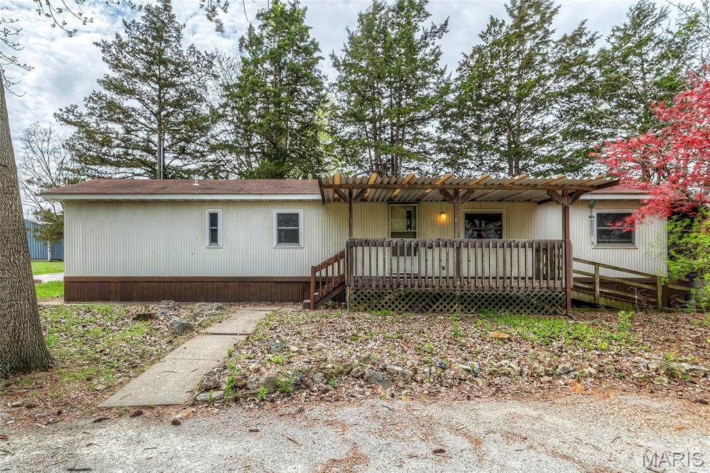 Situated on 0.62-ACRE LOT, surrounded by mature trees, this 2-bedroom, 1-bath mobile home includes a DETACHED GARAGE and is ready for your personal touches. Convenient circle drive leads to COVERED FRONT PORCH which overlooks PEACEFUL WOODED front yard. Entry foyer with coat closet opens to bright living room. Eat-in kitchen features raised-panel oak cabinets to-ceiling, tile backsplash, storage pantry, dishwasher, electric range, vent hood and refrigerator stays. Practical laundry enclosure with included washer and dryer. Each bedroom features laminate flooring and sliding door closet. Bath features extra counterspace and tub/shower combo. Public water and sewer. Trees and landscaping were freshened up post-photos. Easy access to Hwy 61, close to restaurants, shops and 5-acre Mill Park with RIVERFRONT WALKING PATH. Award-winning school district. Agent owner.