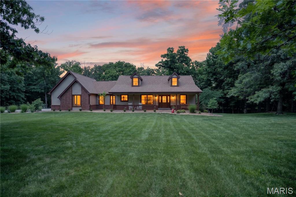 Luxury, privacy, and a peaceful setting come together on this stunning 3-acre estate in the heart of Defiance. Tucked away at the end of a quiet cul-de-sac in sought-after Ridgefield Farms, this beautifully updated ranch is surrounded by mature trees and natural beauty. The property feels like a secluded retreat while remaining just minutes from highways, wineries, restaurants, parks and conservation areas and top-rated Francis Howell schools. Inside, the combination of natural light and vaulted ceilings create an inviting sense of space, while new luxury vinyl flooring throughout much of the main level adds warmth, durability, and modern style. The beautifully refreshed kitchen serves as the heart of the home, featuring granite countertops, freshly painted cabinetry, updated finishes and newer stainless steel appliances. The large area adjacent to the kitchen serves as additional storage and pantry space and could be creatively utilized for a variety of functions. The spacious main living area has a functional wood burning stove and flows seamlessly to the deck overlooking the pool and woods beyond, creating an ideal setting for gatherings large and small. The spacious main-floor primary suite is a private retreat with dual walk-in closets and a luxurious bath complete with double vanities, a soaking tub, and separate shower. Two additional bedrooms, a full bath, and main-floor laundry provide comfortable everyday living, while the finished walkout lower level offers flexibility with two additional bedrooms, a full bath, and large recreation space that walks out to the patio and pool. Step outside to discover what sets this property apart. With a backyard designed for making memories, it features an 18’ x 36’ in-ground pool (new liner in 2024), a dedicated pool house with a half-bath, multiple entertaining spaces, and views of the surrounding woods. Recent improvements are sure to keep the home low cost and low maintenance for years to come. Thoughtful enhancements include an impact-resistant exterior featuring Owens Corning Storm Class IV shingles (2025) and premium Diamond Kote siding (including fascia, soffits, & trim in 2025). An upgraded front entry door with expansive sidelights and a refurbished deck surface complemented by new aluminum railings all completed in the past year. The oversized side-entry garage includes a newly added service door and creates a perfect space for a workshop, hobby area, or additional storage access. For added value, the septic system was replaced in 2023, complete with a new tank and drain field. Opportunities to own a low maintenance property with a huge private lot, extensive updates, and established neighborhood appeal are increasingly rare…don’t miss your chance to be the next owner!