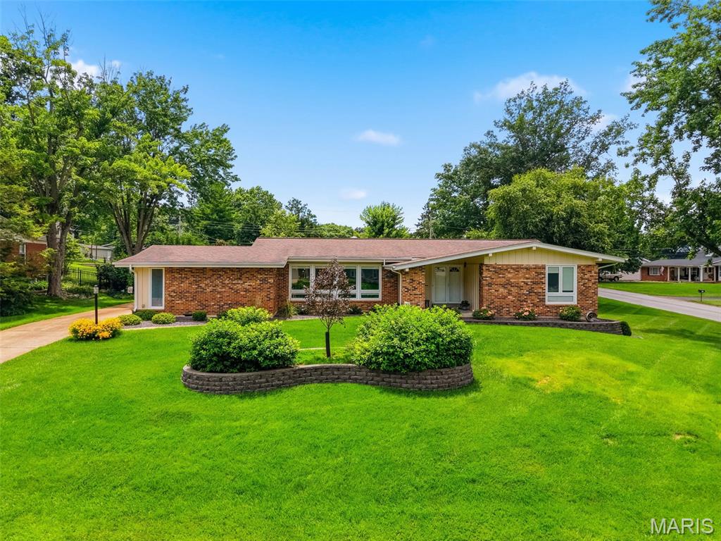 Charming and beautifully maintained brick ranch in the heart of Ballwin showcases true pride of ownership throughout. Oak hardwood floors throughout, abundant natural light, and timeless character create a warm and inviting atmosphere. The formal living room flows seamlessly into the formal dining area, providing an ideal space for entertaining family and friends. The eat-in kitchen features stainless steel appliances, oak cabinetry, a pantry, and ample space for casual dining. Family room with brick fireplace has sliding door out to patio. The spacious main-level primary suite offers dual closets, a ceiling fan, and a private bath, while three additional generously sized bedrooms provide comfortable accommodations for family, guests, or a home office. The finished lower level expands the living space with a large recreation area, half bath, laundry area, abundant storage, and a dedicated workshop or hobby space. Situated on an expansive corner lot, the outdoor living areas include a sprawling fenced backyard, patio perfect for relaxing or entertaining, and a convenient rear-entry garage. Combining classic charm, functional living space, and a desirable location, this Ballwin ranch is ready to welcome its next owner home.