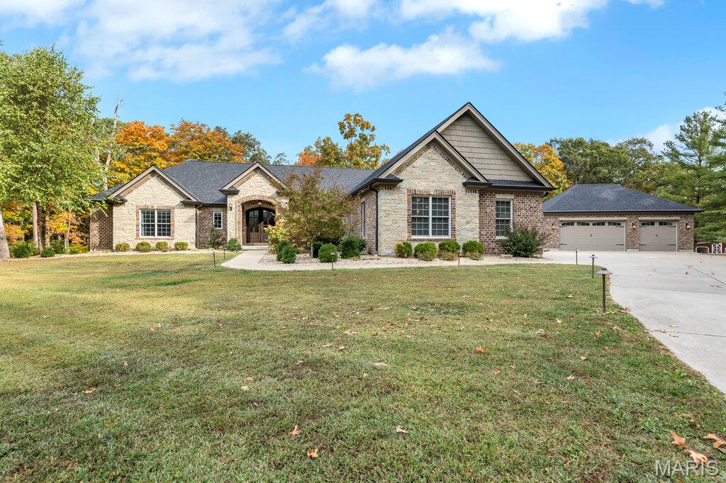 Experience the ultimate in privacy and natural beauty with this stunning custom waterfront property nestled on 37+ mostly wooded acres fronting the serene waters of Callaway Valley Lake. Crafted with exceptional attention to detail, this one-of-a-kind property showcases rich woodwork and impeccable craftsmanship throughout. Highlighted by a grand wood-paneled ceiling with softly arched beams, and a floor to ceiling stone fireplace that lend warmth and architectural elegance to the main living space. At the heart of the home lies an open, elegant luxury kitchen that is sure to impress with custom cabinetry, premium appliances, and generous prep space, making it ideal for both everyday living and entertaining in style. Hop in the side by side and head to the lake to enjoy your own private boat dock, perfect for fishing, kayaking, sunset cruises, or simply soaking in the peaceful lakeside setting. This land is ideal for hunting, hiking, and exploring, offering year-round outdoor adventure in your own backyard. Additional features include a total of 7 garage spaces, a versatile detached 3 car garage, a large chicken coop,  and charming Barn with loft space and concrete floors adding both functionality and character to this exceptional property. All of this is set within a peaceful, wooded landscape that feels worlds away—yet is just minutes from  New Melle, Wentzville and Defiance, Missouri. ATTN: option to just purchase 32+/- acres with the lake frontage, dock and barn Available!! includes Lake Rights!