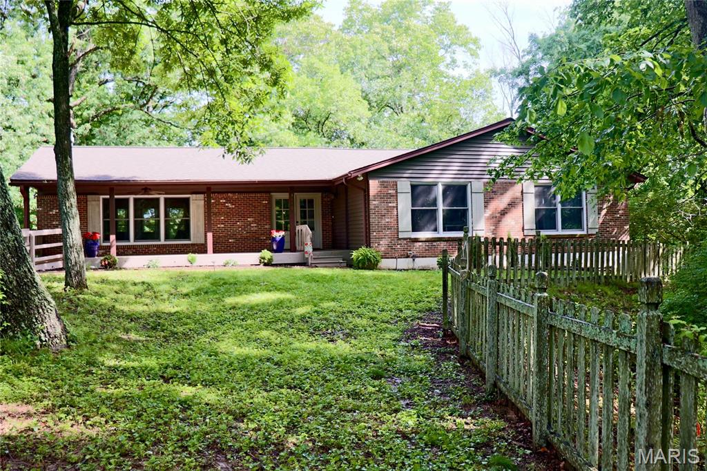 Tucked away on 3 private wooded acres in Wildwood and located in the award-winning Rockwood School District, this spacious ranch offers a rare combination of privacy, space, and natural beauty. Surrounded by mature trees with a partially fenced yard, the setting feels peaceful and secluded while still being close to everything Wildwood has to offer.
Enjoy quiet mornings on the large covered front porch and entertain with ease on the expansive back deck overlooking the scenic property. Inside, the heart of the home is the impressive family room featuring a stunning floor-to-ceiling stone, wood-burning fireplace that creates a warm and inviting focal point. Just beyond, the light-filled kitchen and dining area offer an abundance of space for gathering and entertaining, complete with a center island, pantry, and plenty of natural light throughout.
The main level includes 3 bedrooms and 2 full bathrooms, along with a versatile bonus room ideal for a home office, guest room, playroom, or additional sleeping space. Main-floor laundry adds everyday convenience. The expansive lower level offers abundant storage and additional space to customize for hobbies, recreation, fitness, or entertaining. A 2-car attached garage completes the home.
Major updates include a new roof and gutters in 2024 and new HVAC in 2021. With generous living spaces, a beautiful wooded setting, and a highly desirable location, this property is a wonderful opportunity to enjoy privacy and comfort in the heart of Wildwood. Lafayette High, Wildwood Middle, and Pond Elementary.
