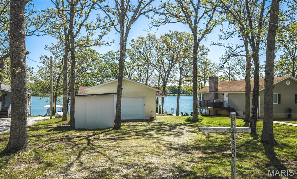Cozy lake house on the main channel gives you great views of all the activity, while the dead end street keeps road traffic to a minimum. The oversized garage will store your boat in the winter and all the lake toys in the summer. Two bedrooms have views of the lake as well as sliding doors to a balcony. Enjoy your morning coffee while you watch the sunrise from the balcony! The lower level has kitchen/dining/living area with sliding doors to a covered porch. The firepit will keep you cozy when you use your lake house in early spring and fall! Walk to your own private dock and enjoy a boat ride. The pontoon boat is included! Indian Lake is  326 acres (+/-) of water fun! Boats, skiing, tubing, jet skis, fishing and swimming will keep the whole family entertained all summer. Community activities include  trivia nights, bingo nights, potlucks, an annual beach party, and MORE. A full service marina ensures boating life is easy. The general store offers the essentials for the lake. Tennis/pickleball courts, basketball, a sandy beach area with playground round out the amenities of the community. The community center hosts many activities and can be rented to members for private functions.
