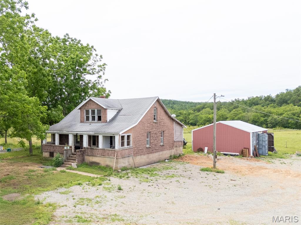 Discover the perfect blend of recreation, farming potential, and country living on this beautiful 29.6-acre property. Featuring mostly open pasture ground with some wooded area, the land offers an ideal balance for livestock, wildlife, and outdoor enjoyment. One of the property's best features is almost 500' of frontage along 12 Mile Creek, a year round spring fed creek with crystal clear water & the multiple springs on the property providing reliable water sources for livestock. The acreage is currently utilized for cattle and is well equipped with good perimeter fencing, cross fencing, with numerous sections being newer. Whether you're looking to continue agricultural use, start a hobby farm, or create your own self-sufficient homestead, much of the groundwork has already been laid. A secluded clearing tucked within the timber provides the perfect location for food plots for the deer and turkey that regularly travel through the area. Improvements include a large 18x34 carport with enclosed sides that is ideal for storing an RV, camper or equipment. A separate metal shop building perfect for projects, storage, or toys is just a bonus. Also located on the property is a historic pink granite stone home. While the structure is currently not habitable and would require extensive renovation, it offers a unique glimpse into the property's past. For those looking to build, the existing homesite presents an excellent location to start from scratch. Water is currently supplied from a spring house, and the existing septic system serves the RV presently located on the property. Conveniently situated just off Highway 67, this property offers easy access for commuting while still providing the rural lifestyle many are seeking. This versatile acreage is ready for its next chapter so you might as well be the one to write it.