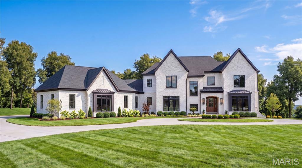 Introducing The Roclare II at Ballas Ridge  — a striking custom residence designed for elevated everyday living. Offering 7,000 finished sqft this transitional masterpiece blends timeless architecture with modern luxury on estate homesites ranging from 1.6 to 6.5 acres within one of Des Peres’ most exclusive new enclaves, with only four rare opportunities available. A grand two-story foyer opens to sweeping sight lines, a formal dining room, private study, and an opulent main-level owner’s suite featuring a spa-inspired bath and expansive dual walk-in closets. The main level is thoughtfully appointed with 10' ceilings (with select vaulted and 12' ceiling spaces), wide-plank hardwood flooring, custom millwork, and a chef’s kitchen designed to impress—opening seamlessly to the breakfast area, hearth room, and spacious great room with fireplace. Enjoy seamless indoor-outdoor living with a covered patio ideal for entertaining, future pool design, or private relaxation overlooking the natural beauty of the homesite. Upstairs offers 9' ceilings, three generously sized bedroom suites with private baths, loft/flex living space, and a second-floor laundry for everyday convenience. A  finished lower level adds exceptional room for recreation, 5th bedroom and full bath.Surrounded by rolling terrain, mature trees, and serene water features, Ballas Ridge offers a rare combination of privacy and convenience near top-rated schools, premier dining, luxury shopping, hospitals, and major highways inquire and build today.