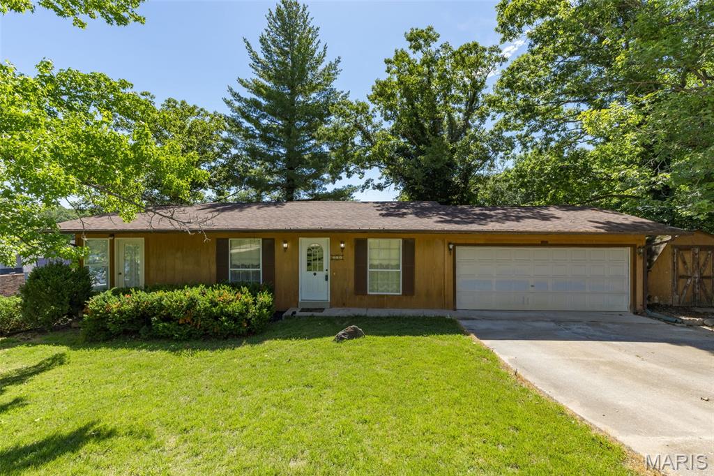 Welcome to your lakeside escape in Terre Du Lac! Situated on a nicely landscaped corner lot, this charming home perfectly blends comfort and stunning lake views.  The main level features a massive living room designed for gathering, a main-floor bedroom, a full bath, and an bright eat-in kitchen that walks directly out onto the enclosed back porch—your new favorite spot for morning coffee with views overlooking the water. Downstairs, the walkout lower level adds incredible versatility and cozy character, complete with a warm fireplace, additional bedroom and full bath, and more lake views.  Storage and hobbies are a breeze thanks to the attached two-car garage and a handy backyard storage shed. Best of all, move in with peace of mind that the roof and HVAC are both about a year old. Don't miss this gem- schedule your tour today!