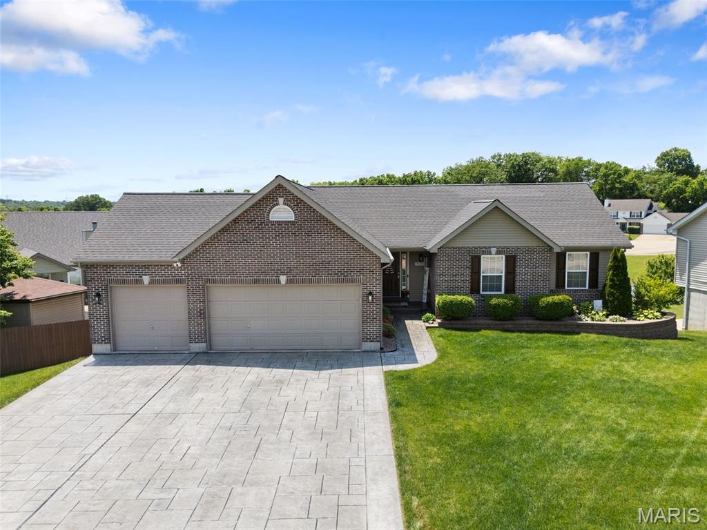 Welcome to your dream home! This beautifully maintained 3-bedroom, 2-bathroom walkout ranch offers 2,200 +square feet of bright, open living space. The inviting entry foyer opens to soaring vaulted ceilings that flow seamlessly through the great room and into a chef-ready kitchen. The kitchen features rich cherry wood cabinetry, designer countertops, a massive walk-in pantry, a subway tile backsplash, and stainless steel appliances. Adjacent to the kitchen, the sunlit dining area opens directly to the maintenance free deck via sliding glass doors. Retreat to the main-floor master suite, complete with a sprawling walk-in closet and a private bath featuring a dual-sink vanity and a seated shower. Two additional main-floor bedrooms, a second full bathroom, and a dedicated laundry room offer ultimate convenience. The massive 42’x27’ finished walkout lower level with huge walk in closet provides endless possibilities for entertainment, a home gym, a media room, or whatever you like! Outside, enjoy peaceful, tree-lined big sky views from your deck or front poch. You will love the huge 3 car garage with stamped concrete driveway! This gorgeous home, yard and landscaping have been meticulously maintained. Dont miss this amazing home!
