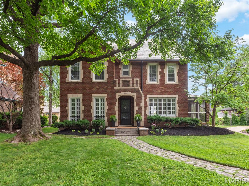 Set directly across from Carondelet Park and just moments from neighborhood restaurants, shops, schools, and churches, this distinguished residence captures the timeless appeal of Holly Hills. From the street, its striking brick and stone exterior, slate roof, Juliet balconies, mature landscaping, and generous lot create an unforgettable first impression. Inside, a gracious foyer features gleaming hardwood floors, original millwork, and soaring ceilings that reflect the home’s historic character. The expansive living room, centered around a woodburning fireplace, offers a warm and elegant setting for both everyday living and entertaining. Custom French doors open to a large, screened porch, ideal for summer evenings and al fresco dining. Nearby, a bright breakfast nook connects seamlessly to the recently refreshed kitchen, designed to accommodate both casual meals and effortless hosting. At the front of the home, the spacious dining room is enhanced by twin French doors with Juliet balconies and custom moldings. A powder room completes the main level. Upstairs, four generously sized bedrooms feature fresh paint, hardwood floors, and abundant natural light. The recently renovated full bath is beautifully appointed with a separate tub and shower, double vanity, and custom tilework. A walk-out basement presents exceptional potential for additional living space, while the large fenced backyard and detached two-car garage complete this remarkable offering.