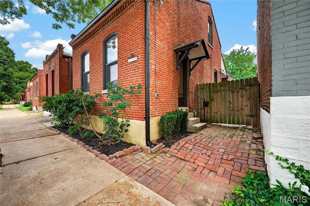Step into the charm of yesteryear in this circa-1885 cottage nestled in the heart of Historic Benton Park. From the moment you enter you'll be drawn-in by the warmth of the exposed brick wall, soaring ceilings, and tall arched windows that fill the spacious living area with natural light.
French doors lead to a versatile bedroom or dining space and continue into the bright, oversized kitchen featuring original pine floors, a breakfast bar and a cozy breakfast nook. Just off the kitchen, a partially covered deck offers the perfect spot for morning coffee, quiet evenings, or entertaining friends and family.
The second bedroom is privately tucked away upstairs and features oversized closets and lots of storage space which is a valuable feature in a historic home. 
Predominately hardwood floors flow throughout the home, adding to its timeless appeal. Situated in the fully fenced backyard is a second deck perfect for grilling, relaxing, and entertaining.
Fresh paint inside and out and spacious, this charming home is just a few blocks from Benton Park and within walking distance of some of St. Louis' finest restaurants, shops, live music, and nightlife. Historic character, modern comfort, and an unbeatable location come together in this Benton Park gem.