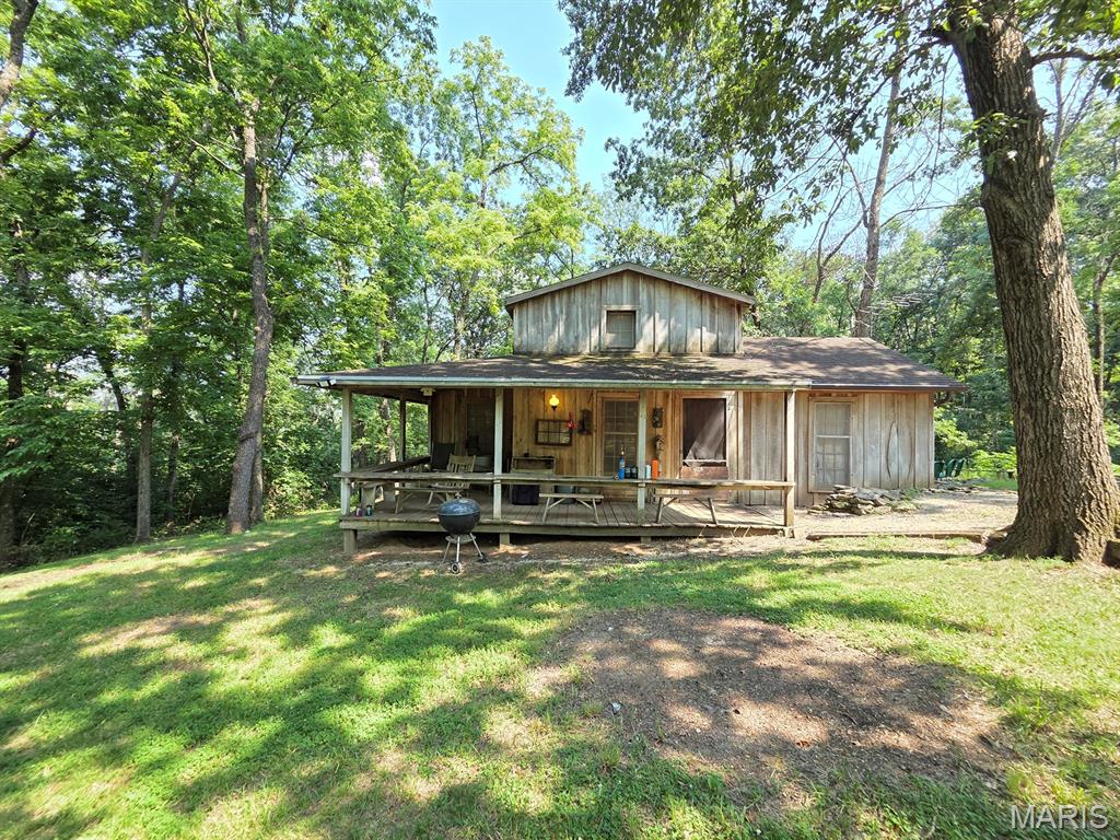 Take a step back in time and enjoy this perfect setting!  As soon as you turn down the tree-covered driveway you'll appreciate what you see - a quiet cabin with a wraparound front porch tucked back in the timber waiting for you away from the rest of the world.  This quiet setting offers a comfortable cabin with all of the necessities - electric & public water are connected.  The main level features a cozy kitchen/dining area with the vintage wood stove, sink, cabinets & more to convey.  A full bathroom and 12x16 master bedroom round out the main level.  Upstairs you'll find a loft bedroom big enough for two beds.  The covered front porch is comfortable even on hot summer afternoons as it is completely shaded!  Take advantage of the sprawling back patio/fire pit area on summer nights.  Tucked in the timber you'll find picnic tables and a horse shoe pit, with deer & wildlife abounding everywhere.  This timber is flanked by tillable bottom ground bordering the Fabius River, making it a main passageway for whitetails.  

This is comfortable enough to live in year-round, but would also make a perfect deer camp, or a unique AirBNB investment property.  Located just south of Newark, utility providers here include REC Electric & Knox County Water.   Propane is available but not currently hooked up.  

This one has been in the same family for generations, and not likely to be available again anytime soon, don't let it pass you by!