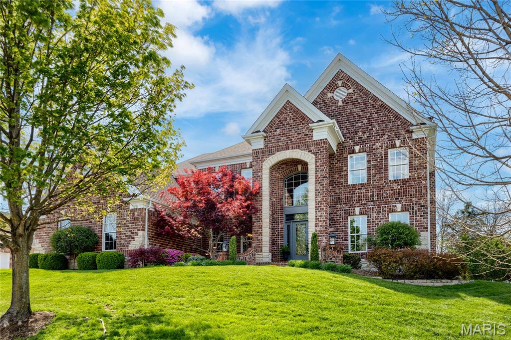 An impressive brick & stone elevation highlights the remarkable curb appeal of this spectacular 2 Sty. Dramatic brick porch entrance with wing walls & leaded glass door leads to 2-sty foyer, private study with sliding barn door, formal dining room with detailed trim work & spacious family room with wide bay window & marble fireplace flanked by built-in bookcases. Designer kitchen featuring 42” gray cabinetry, quartz countertops, premium appliances & 8’ center island adjoins breakfast room with wet bar & convenient planning center & vaulted hearth room with floor-to-ceiling fireplace. Coffered primary bedroom suite with luxury bath with freestanding tub offers an appealing retreat. 3 Additional bedrooms, 1 with ensuite bath & 2 with Jack n’ Jill bath, complete the 2nd floor living quarters. Lower Level includes recreation room with wet bar & media room plus workout room & guest suite. Atrium doors open to outdoor living room with grilling station & brick fireplace & patio with firepit.