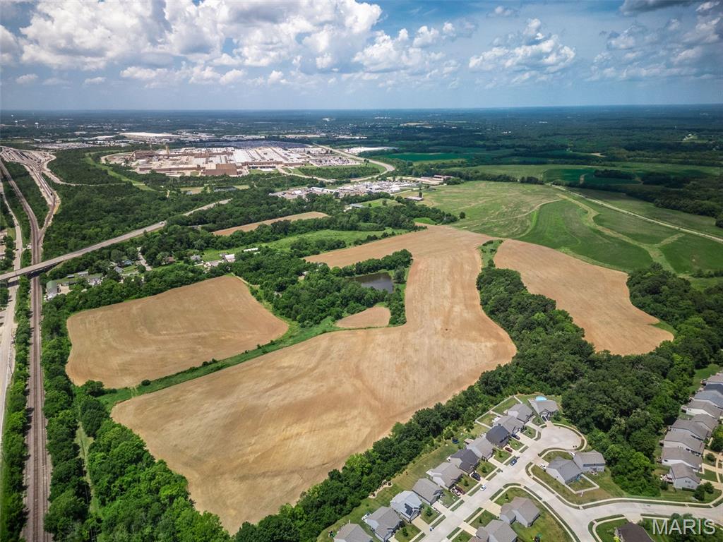 Approximately 88.5 undeveloped acres (subject to final survey) in Unincorporated St Charles County. Property is located off of Gilmore road off Hwy A, to the North/East of the GM Plant., to the West of Fox Ridge Subdivision, and to the South of acreage purchased by Ameren for their training facility. Pond in center is approx 1.5 acres and is 15-20' deep per owner and stocked with fish. Property is being primarily farmed with no lease in place, Ground is level, some rolling and includes 3 Parcel IDs. One has a home on 1.65 acres (2121 Gilmore), 5.01 acres Gilmore Lane will be divided for owners to keep outbuildings and business, 86.26 acres at 2133 Gilmore Lane. The St Charles County Master Plan 2030 has this property as Industrial, Office, Distribution, Warehouses and Manufacturing with secondary uses noted as Supporting Retail or Office Uses. This includes outdoor storage and heavy industry. There is large interest in rezoning this parcel to Medium Residential similar to the subdivision to the East of this property; any of these uses would require re-zoning approval.  Located at the "Crossroads of the Nation" at the intersection of I-70 and US Highway 61 (I-64) , major access to transportation facilities, convenient hub for transportation and business development. Beside the Norfolk Southern Railroad. Any buildings will be sold in AS-IS condition. All showings must be made by confirmed appointment to access the property.