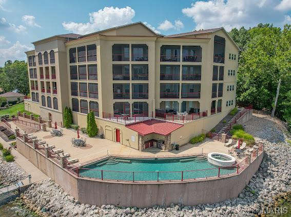 WELCOME HOME to BELLA SERA LOCATED at THE 31 MM at the 4 CORNERS POINT with AMAZING VIEWS OF THE LAKE OF THE OZARKS. THIS GROUND LEVEL, NO STEP ENTRY, ONE OWNER UNIT is the PERFECT set up for FULL Time living. OPEN CONCEPT W/3 BEDROOMS, 3 FULL BATHS, LIVING and DINING AREA. with a FULL WALL of  WINDOWS, ELECTRIC FIREPLACE,  GRANITE COUNTERTOPS, LARGE CENTER ISLAND, CUSTOM CABINETRY, TILE BACKSPLASH, STAINLESS APPLIANCES, A LARGE MASTER  RETREAT with a TILE WALK in SHOWER, CORNER jetted TUB,  LARGE DOUBLE VANITY, WALK in CLOSET, SLIDING  DOORS to your private PATIO. THIS UNIT OFFERS 2 ON-SUITES offering  EXTRA PRIVACY for GUESTS. EXPANSIVE OUTDOOR SPACE, A MASSIVE 900sq ft  COVERED and OPEN AIR PATIO. THE ONLY UNIT With A GATE  perfect for the PET Lovers . A FULL BASEMENT UNDERGROUND PARKING GARAGE, ICE MACHINE, fill the cooler on the way to the DOCK, USE the RAMP or STAIRWAY to docks, THIS UNIT has 2 GARAGE SPACES, 16X40  BOAT SLIP, and PWC. THIS BEAUTY with ALL NEUTRAL COLORS THROUGHOUT, CERAMIC TILE IN KITCHEN, DINING  & BATHS, NEW LVP FLOORING IN THE LIVING AREA. CUSTOM BLINDS. THE COMMON OUTDOOR  AREA INCLUDES,  INFINITY STYLE SALT WATER POOL, OUTDOOR KITCHEN, POOL BATH, HOT TUB, ELEVATOR ACCESS to ALL LEVELS, DOCKS W/ BREAKWATERS. THIS LOCATION IS PERFECT FOR BOATING and VISITING THE GREAT LAKESIDE RESTAURANTS, THE FISH & CO. CAPTAIN RONS, LARRY WOOD and THE NEWER CAVE RESTAURANT.  THIS COMPLEX HAS ONLY 20. UNITS TOTAL  NO SHORT TERM or NIGHTLY RENTALS.