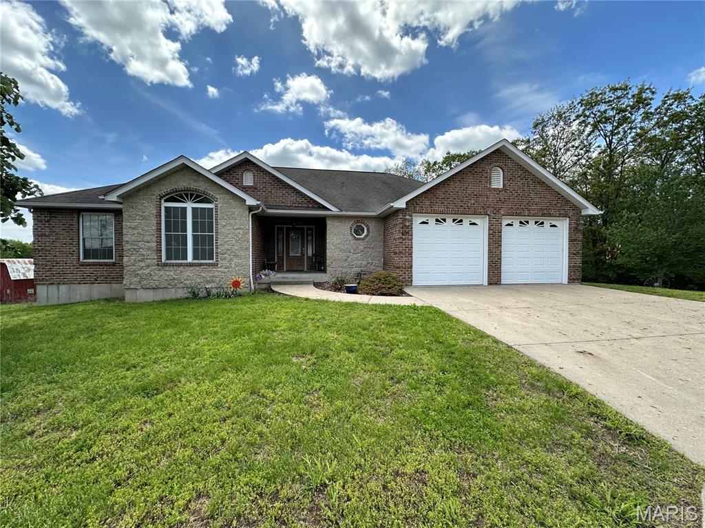 Exceptional One-Owner Custom-Built Home Offering Quality, Comfort & Timeless Design!
Pride of ownership shines throughout this meticulously maintained one-owner custom-built home. From the moment you arrive, you'll be impressed by the stunning exterior featuring a beautiful blend of brick, stone, and upscale vinyl siding, creating outstanding curb appeal and lasting quality. Step inside to discover an inviting open-concept floor plan designed for both everyday living and entertaining. The well-appointed custom kitchen is the heart of the home, featuring custom maple cabinetry, a center island with raised breakfast bar, abundant workspace, over-cabinet lighting, and a spacious walk-in pantry. Beautiful maple hardwood floors add warmth and elegance. This thoughtfully designed home offers 3 spacious bedrooms, 2½ baths, and wide interior doorways throughout for enhanced accessibility. The oversized primary suite provides a relaxing retreat complete with a large walk-in closet, walk-in shower, and generous bedroom space.
Convenience abounds with main-floor laundry and a dedicated workshop room located behind the attached two-car garage. The garage is equipped with floor drains, making maintenance and cleanup a breeze.
Enjoy outdoor living on the covered back porch, the perfect setting for grilling, entertaining guests, or simply relaxing and enjoying the peaceful surroundings. The full walkout unfinished basement offers endless possibilities and serves as a blank canvas for future living space, recreation areas, or additional bedrooms, in addition there is an abundance of storage. For added peace of mind, the home also includes a secure safe room. Impeccably cared for and thoughtfully designed, this remarkable property combines superior craftsmanship, functionality, and comfort in one exceptional package. Homes of this caliber rarely become available—don't miss your opportunity to make it yours!