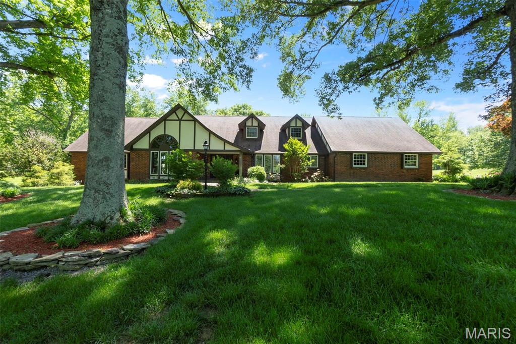 WARM, INVITING, COMFORTABLE, SPECIAL... all words to describe this beautiful English-Tudor style home. The current owners had this home custom built, with lots of love and a focus on quality and functionality. It sits on 8.76 acres and the next owner is sure to enjoy the personal privacy afforded with a view of nature and wildlife from the all-weather porch, deck, and patios, in addition to the in-ground pool area. There are too many unique features to list...Huge family room with tongue and groove wood ceilings, rough sawn cedar wood walls throughout, spacious vaulted-ceiling dining room for entertaining, two fireplaces, master suite and four additional bedrooms above-grade, with another in the lower level. The owners recently added a full kitchen and laundry in the basement for hosting extended family if needed. The roof, windows and solar panels are approximately ten years old. This property is perfectly located just outside the City limits of Cape and in Jackson School District!