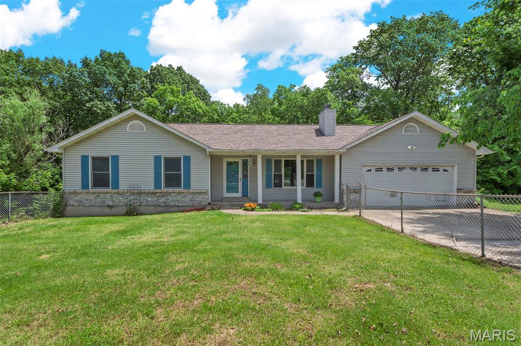 Tucked away on 3 beautiful, private acres surrounded by mature trees, this property offers the peaceful setting you’ve been searching for! Situated on a quiet cul-de-sac in a small, fully established subdivision of just 12 homes, this property is ideal for those seeking privacy, space, or even the perfect opportunity to start a small homestead. Enjoy the perfect place for a garden area near the bonfire pit, scenic wooded views, and breathtaking sunsets from the west-facing front of the home. The sunroom at the back of the home fills with morning light, making it the perfect spot for plants and enjoying your morning coffee. Both the sunroom and primary bedroom open to the deck for easy indoor-outdoor living. You will also find two full bathrooms, main floor laundry, a walk-in primary closet, attic storage with two separate access points, a large basement with partial finishes including a bathroom rough-in, and an attached 2-car garage. Designed with accessibility in mind, the home features wide hallways and door frames throughout. It is currently configured as a spacious 2-bedroom but could easily be converted back to a 3-bedroom by reinstalling a wall in the oversized secondary bedroom. Additional quality features include solid brick and mortar construction on the front exterior, Andersen windows and doors, public water service, a roof that is only 2 years old, and an updated exterior A/C unit replaced approximately 3-4 years ago. With solid bones, endless potential, and rare privacy and scenery, this property is ready for its next owner to make it their dream retreat!