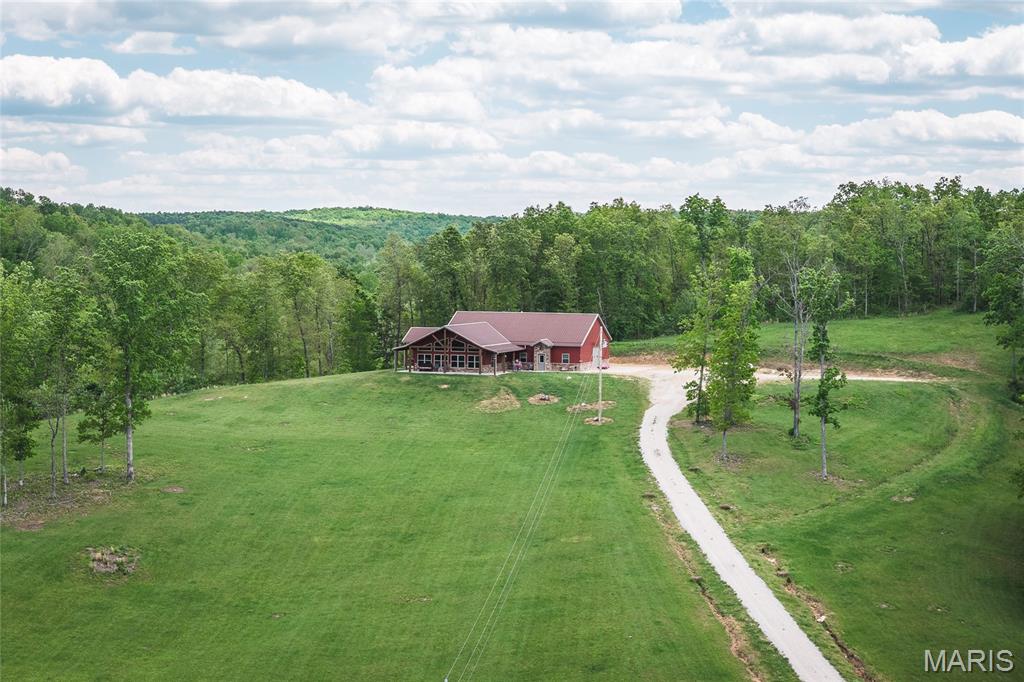 Escape to the Ozarks with this stunning farm in Crawford County, Missouri, offering the perfect blend of comfort, scenery, and outdoor recreation. Perched atop a hill, the 2,200 sq ft home boasts views that truly capture the beauty of the surrounding countryside. The home features 2 bedrooms and 3 bathrooms, and  a non-conforming  room/office providing plenty of space for family, guests, or a weekend retreat. An attached garage adds convenience and functionality, complete with a storage loft area above—perfect for keeping tools, equipment, or seasonal items organized. Inside, you'll appreciate the craftsmanship and attention to detail throughout. The kitchen showcases completely custom cabinetry, while custom woodwork extends into the flooring and other finishes across the home, giving it a warm, high-end, one-of-a-kind feel. Recent exterior updates add even more value and peace of mind, including new gutters with gutter guards and the home being freshly stained in December 2025, enhancing both durability and curb appeal. The land features a desirable mix of open pasture and hardwood timber, making it ideal for farming, recreation, or a private retreat. Crooked Creek winds its way through the middle of the property, providing year-round water and adding incredible natural character. This property is a haven for wildlife, with abundant deer and turkey, making it a prime hunting property for all seasons. Several open areas are ready for food plots to further enhance your hunting opportunities. Located just 15 minutes from Steelville, 5 minutes from Crooked Creek Conservation Area, and only minutes from the Meramec River, you'll have quick access to some of the best floating, fishing, and outdoor recreation Missouri has to offer. The owner has also added a Generac backup power system for added peace of mind. Call today to view this amazing property.