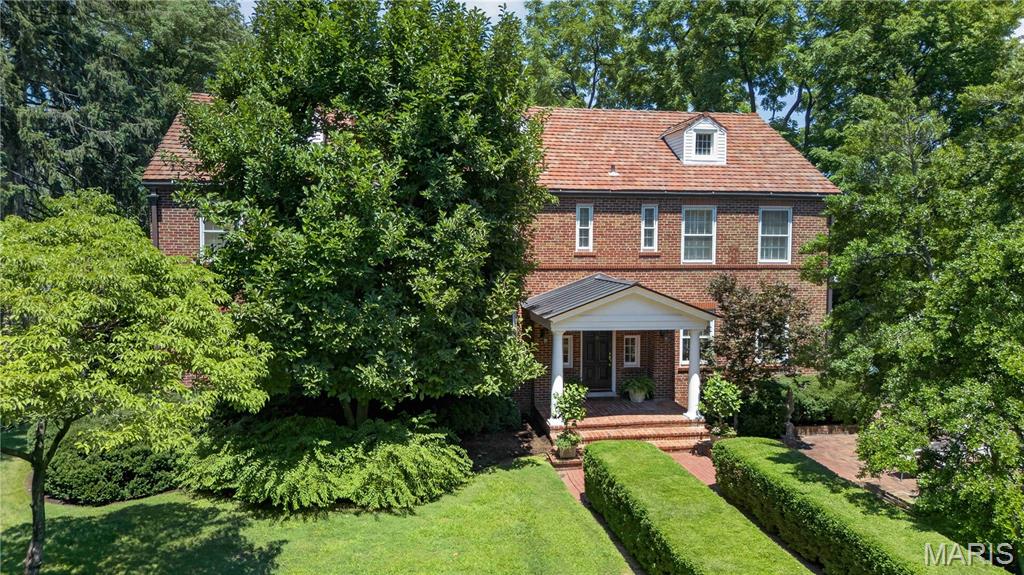 Built in 1936, this charming 4-bedroom, 4.5-bath home beautifully blends timeless architectural character with thoughtful modern updates in a prime Ladue location. From the moment you arrive, the inviting front patio and picturesque 1+ acre lot set the tone for this special property. Inside, rich wood floors, high ceilings, and significant architectural details create warmth and elegance throughout. The spacious living room offers an ideal setting for both everyday living and entertaining. A functional main-floor laundry room adds convenience to the home’s classic layout. The expansive primary suite is a true retreat, featuring a private sitting room or office, generous closet space, and a spacious bath with separate vanities, a soaking tub, and large shower. Three additional bedrooms and two full baths complete the second floor, offering ample space for family and guests. The finished lower level provides additional living and entertaining space along with a full bath, ideal for a recreation room, fitness area, or guest suite. Surrounded by mature landscaping and set on over an acre, this exceptional property offers privacy, beauty, and convenience in one of Ladue’s most desirable locations. A rare opportunity to own a home filled with charm, character, and modern comfort.