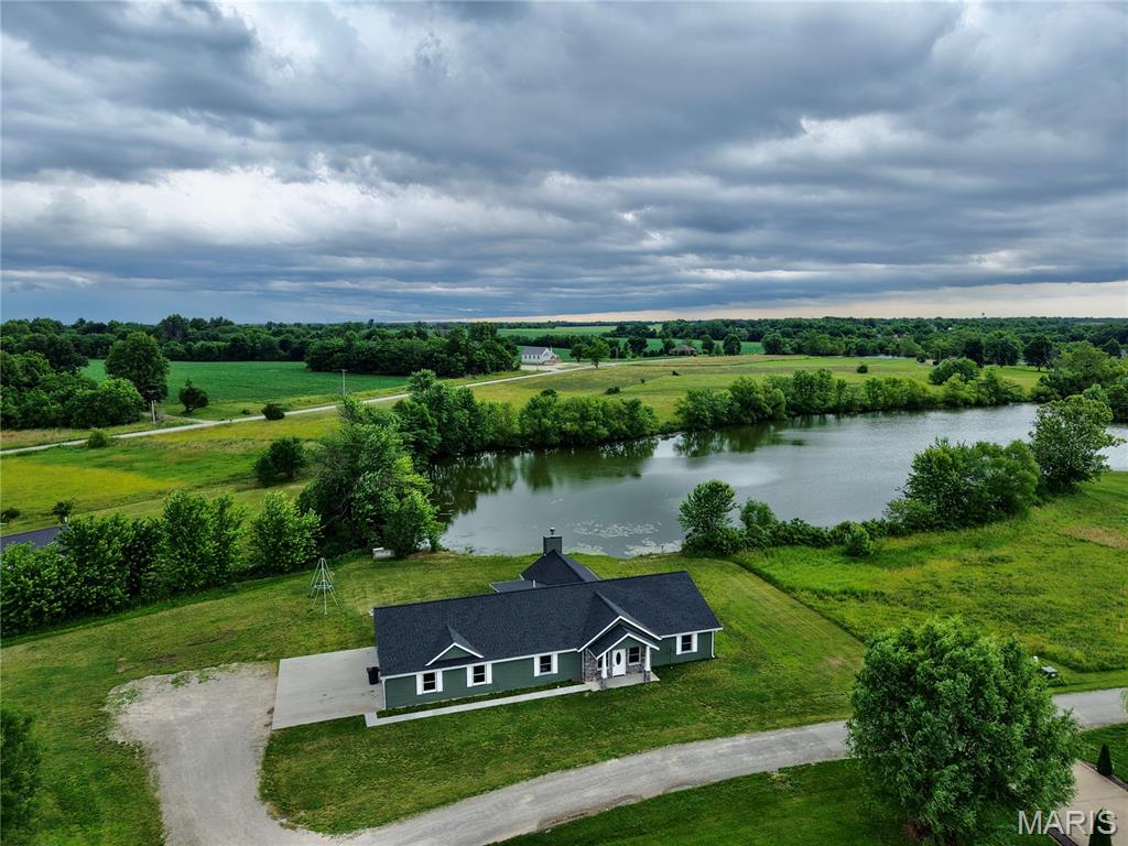 Built in 2024 and sitting right on the lake at the end of a private dead-end road, this 2,304 sq ft home checks every box. The vaulted hearth room with wood-burning fireplace faces the water, it's the kind of room you never want to leave. Granite countertops, gas stove, walk-in pantry, surround sound, and geothermal HVAC keep everyday living effortless. The primary suite is a true retreat, featuring a stunning onyx shower and walk-in closet. Two additional bedrooms, a full bath, on a slab foundation. The oversized 24×36 attached garage and a second detached 36×24 garage tucked behind the tree line give you more space than most lake properties can dream of. This property sits on 1.22 acres across four lots, public sewer, and high speed internet.