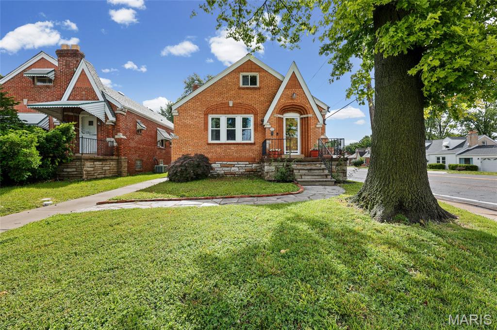 Step up the charming stone walkway and into this storybook gingerbread-style home, where timeless character blends beautifully with modern updates. Inside, you'll find rich wood floors, graceful arched doorways, original doors, and stunning stained-glass windows that showcase the home's historic charm. The inviting living room centers around a handsome stone fireplace, while the formal dining room provides the perfect setting for gatherings. The stylish black-and-white kitchen offers classic appeal, complemented by fresh neutral paint colors throughout.

The main level features a primary bedroom with an enormous walk-in closet plus a second bedroom.  Upstairs you'll find two additional bedrooms and a versatile bonus room ideal for an office, playroom, or hobby space. The lower level adds extra living potential with paneled walls and a convenient half bath.

Enjoy morning coffee or evening relaxation in the back sunporch. Outside, a freshly poured patio creates the perfect space for entertaining, while the partially fenced corner lot offers room to play, garden, or unwind. Completing the property is an oversized detached one-car garage, providing excellent storage and workspace. This enchanting home is filled with warmth, character, and the unique architectural details that are increasingly hard to find. Showings start Monday, June 8th.