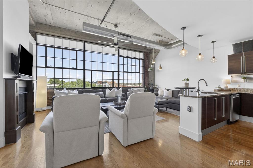 Set within the historic West End Lofts — a former Model T factory reimagined for modern living — this sophisticated residence blends industrial character with elevated design. A dramatic north-facing wall of windows fills the open living space with natural light, while exposed brick and concrete ceilings create the perfect backdrop for chic urban living. Designer lighting, custom blinds, and rich wood floors add warmth and style throughout. The stylish kitchen anchors the main living area with granite countertops, Italian cabinetry, stainless steel appliances, and a custom tile backsplash — ideal for both everyday living and entertaining. Tucked down the hall, the spacious primary suite offers a large walk-in closet and a stunningly updated spa-inspired bath featuring a separate shower and luxurious 6-foot soaking tub. An additional bedroom and full bath provide flexibility for guests or work-from-home living, while the in-unit laundry closet and private storage space add convenience. NEW HVAC in 2023. West End Lofts offers an exceptional lifestyle with resort-style amenities including a pool, fitness center, billiards room, guest suite, gated secure parking with new EV charging stations, and a beautifully updated lobby. Ideally located near Wash U Medical School, BJC Campus, SLU, Cortex, and the restaurants, coffee shops, and nightlife of the vibrant Central West End. Condo fee includes: water, sewer, gas, trash, basic cable, internet & amenities. Welcome home!