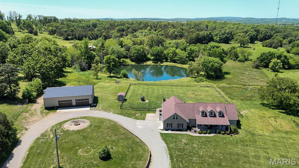 20 Acres of Waterfront Serenity with Exceptional Outbuilding!
If you’ve been searching for land that truly delivers, this 20-acre country estate is a rare find. Offering a private stocked pond, abundant wildlife, cleared and usable acreage, and a brand-new high-quality shop, this property is perfectly suited for outdoor enthusiasts, hobby farmers, or anyone seeking space and privacy without sacrificing convenience.
The highlight of the property is the beautiful stocked pond, ideal for fishing, relaxing, and soaking in peaceful water views right from your own backyard. Surrounded by scenic countryside, the  20 acre land also features an established food plot, attracting abundant wildlife for viewing or recreation. Nature lovers and gardeners will appreciate the wild blackberry patch, apple trees, and grape vines, while the open land provides endless opportunities for recreation, animals, gardening, or simply enjoying wide-open spaces.
A major asset of the property is the brand-new 40x56x14 shop, built with a concrete foundation and equipped with two 10x16 overhead doors. This exceptional outbuilding offers ideal space for equipment, vehicles, recreational toys, livestock support, or a serious workshop.
Complementary the land is a gorgeous spacious 3,000 + sq ft home with a sought after divided floor plan designed for comfortable country living. Inside, the open layout centers around the kitchen with granite countertops, hickory cabinets, center island, walk-in pantry, breakfast bar, and double ovens—perfect for large gatherings after a day outdoors. The living room features a gas fireplace, adding warmth and charm, along with a separate dining room space. 
The primary suite provides a private retreat,  soak tub, double sinks, beautiful stone walk-in shower also featuring a walk-in closet that doubles as a secure safe room with ventilation and phone access. The spacious main level offers 2 more nice size bedrooms one with attached full  bath and a hall bathroom perfect for guest. Main level is completed with laundry room with added utility sink. Fully finished upper level features bonus room, half bath, bedroom and office space an additional 700+ of livable space. 
Outdoor living is more welcoming with a covered front and back porches overlook the pond and scenic acreage, making them perfect spots to enjoy sunrise coffee, evening sunsets, or watch wildlife roam. An outdoor wood-burning furnace adds efficiency and practicality for rural living.
This property delivers the complete rural package: water, acreage, outbuildings, privacy, and a comfortable home—all just minutes from Farmington. Whether you’re fishing at your pond, working in the shop, harvesting from the land, or simply enjoying the quiet, this is a place where lifestyle and land come together to make memories with your family and friends. Don't want to miss this beauty!