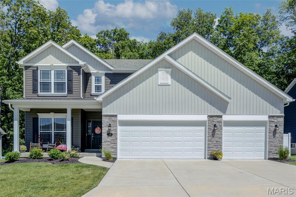 Experience the perfect blend of country charm and modern convenience at this stunning 2022 Houston Homes-built Ash floor plan in the highly desirable Majestic Lakes community. Situated on a premium lot backing to mature trees, this beautifully maintained home offers exceptional privacy and peaceful views while enjoying neighborhood amenities including a clubhouse, swimming pool, and picturesque ponds with fountains.
Impressive curb appeal welcomes you with a covered front porch and attractive stone elevation. Inside, a gracious foyer opens to a bright and spacious floor plan , abundant natural light, and a warm great room highlighted by a gas fireplace. The beautifully appointed kitchen is designed for both everyday living and entertaining, featuring quartz countertops, a large center island, tile backsplash, stainless steel appliances, gas range, and a walk-in pantry. The main-floor laundry and mudroom provide added convenience and storage.
Upstairs, you'll find a versatile loft area along with generously sized bedrooms, each offering ceiling fans and walk-in closets. The spacious primary suite features a tray ceiling accented by crown molding, ensuite bath with oversized shower and linen closet.  Throughout the home, neutral designer colors painted with premium finishes create a fresh, move-in-ready backdrop to complement any style. All window blinds are included, making your transition effortless.The unfinished lower level offers excellent future potential with an egress window ready for additional living space, recreation area, home office, or gym. Outside, enjoy the level fenced backyard, large concrete patio, attractive landscaping, and the bonus of additional property extending beyond the newer PVC privacy fence to a wooded backdrop. Complete with a 3-car garage and located on a quiet perimeter street within the Troy School District, this exceptional home combines privacy, space, and modern finishes in a truly desirable setting.