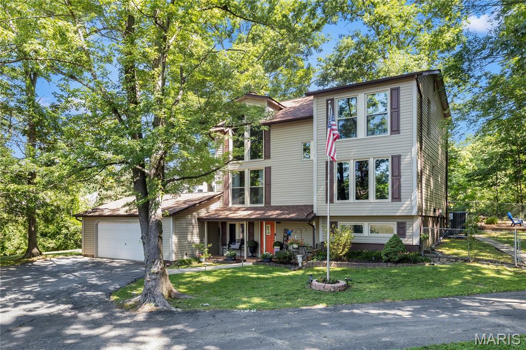 Rare opportunity in the sought-after Hickory Hollow neighborhood in Fenton! This spacious multi-level home offers 3 bedrooms, 2 bathrooms, 1,842 sq ft above grade, and over 2,600 sq ft of total finished living space across three finished levels. Surrounded by mature trees and nature, this home offers privacy and a peaceful setting while still being close to shopping, dining, and highways.

Features include two separate living rooms, a cozy wood-burning fireplace in the main living area, and a spacious primary with vaulted ceilings and skylights. The lower-level entertaining area includes a custom St. Louis Blues-themed bar perfect for hosting family and friends. 

Enjoy the large rear deck overlooking the private backyard, plus an additional driveway ideal for a camper, boat, or extra vehicle parking in addition to the large attached garage. Major updates include newer roof, HVAC system, new windows, and water heater. Homes in Hickory Hollow rarely come available-don’t miss this unique opportunity!