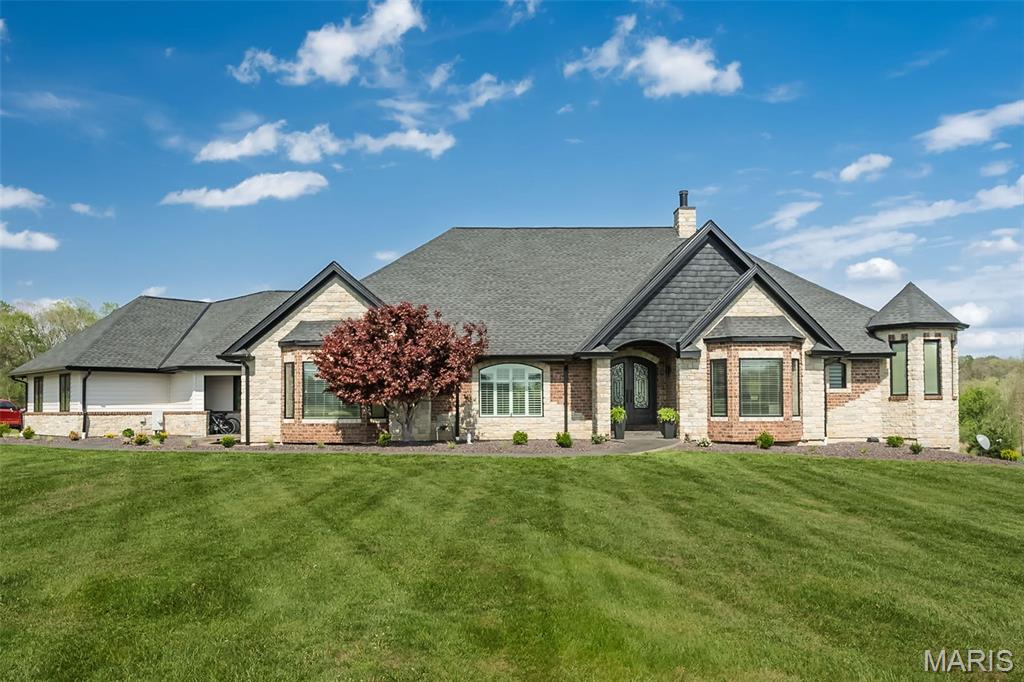 This refined estate blends timeless architecture with a warm, modern sensibility.  Spanning approximately 6,500+ square feet, with 4 bedroom, 4 full baths, 2 half baths plus, the home was designed to magnify scale, flow, and livability.  Every detail reflects thoughtful craftsmanship and an effortless connection between form and function.  The entryway sets the tone—inviting, grounded, and intentional.  It introduces a living experience that feels boundless, balanced, and beautifully alive.  At the center and of course, the heart, lies a dramatic great room and kitchen environment designed for both everyday living and elevated entertaining.  High Tray ceilings, refined finishes, and sweeping views define the space, while the open layout encourages connection and comfort.  Broad living spaces connect seamlessly, blurring the boundaries between indoor and outdoor.  Screened Patio area of 20' x 20' The grounds offer both privacy and tranquility, creating a cohesive setting that feels relaxed yet elevated. 
The Ultimate Addition -a fully customized, nearly half-million-dollar addition introducing a remarkable 56' x 28' 7-car garage—an extraordinary feature that combines functionality with design excellence. This space redefines convenience and craftsmanship, offering versatility for collectors, enthusiasts, or those who simply appreciate exceptional detail.   New Roof.  New Cedarmax Insulated Siding. Lake Amenity.  This is your next home.  Situated within one of St. Charles County’s most exclusive communities, this estate offers a rare combination of security, privacy, and proximity to city amenities. Make your appointment to see today