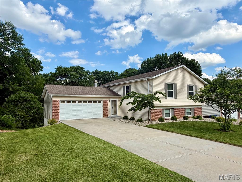 Rare opportunity to own a beautifully updated split-level home backing to wooded common ground, Spencer Creek, and the Spencer Creek Trail. This move-in ready home offers 4 bedrooms, 3 full bathrooms, and over 2,300 square feet of finished living space. The bright, open main level features luxury vinyl flooring, abundant natural light, and an updated kitchen with white cabinetry, solid-surface countertops, stainless steel appliances, recessed lighting, and a large peninsula ideal for entertaining.

The finished walkout lower level includes a spacious family room with a wood-burning fireplace, a fourth bedroom, full bathroom, laundry area, and extensive storage space, making it ideal for guests, a home office, or multi-generational living.

Enjoy wooded views from the composite deck and patio while taking advantage of the home's private backyard setting. Located just steps from the Spencer Creek Trail and a short walk to Laurel Park, residents enjoy convenient access to walking trails, a public pool, pickleball courts, playgrounds, and sports fields. 

Additional features include a 2-car garage, updated bathrooms, and generous storage throughout. Conveniently located approximately one mile from I-94/US-40 and minutes from shopping, dining, Rec-Plex, and award-winning Francis Howell schools, this home offers the perfect combination of outdoor recreation and everyday convenience.