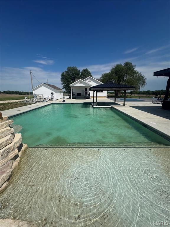 Escape to Your Private 21.5 +/- Acre Oasis in Wright City Missouri

Experience the perfect blend of modern luxury and rustic tranquility in this stunning 2,398 square foot renovated farmhouse. Situated on over 21.5 +/- sprawling acres set behind a secure, solar-powered 18ft gated entrance, this 3-bedroom, 2.5-bath estate offers unparalleled privacy on over 21.5+/- sprawling acres. This property offers ultimate privacy without sacrificing a single high-end amenity. Step inside to a freshly renovated interior featuring farmhouse charm with contemporary finishes that provide a bright, move-in-ready living experience. The freshly renovated interior boasts all new hardwood floors, new fresh paint, new base trim, new modern lighting fixtures, new recessed can lights, and new fans throughout. Every detail has been addressed, including new windows, new HVAC system, new architectural roof, new water heater, and a water softener system. The chef-inspired kitchen is a true standout, featuring a coffee bar, new custom cabinetry and elegant granite countertops, new dark stainless-steel appliances, including a flattop stove and double oven, new deep-basin sink and new stylish tile backsplash. 

The Exterior & Luxury Backyard of your dreams:
Why go on vacation when your backyard rivals a five-star resort? The outdoor entertainment complex is truly unmatched, a must see, boasting all new concrete through the whole complex. Enjoy the outdoors from one of three new composite porches finished with sleek black aluminum railing. A 30 x 50 massive heated in-ground pool features a custom grotto waterfall, spraying water features, and a swim-up bar complete with in-pool seating. For ultimate relaxation, enjoy the integrated tanning ledge with in-pool fiberglass chairs.

The Gourmet Outdoor Kitchen: A chef’s dream equipped with two cooktop grills, a flat-top grill, icemaker, refrigerator and a microwave. Stay cozy by the outdoor firepit area or under the integrated overhead heaters during cooler evenings. Host the big game with two flatscreen TVs and sophisticated under-bar lighting that sets the mood for nighttime gatherings. You can show off your putting skills on the putting green, play some Bocce Ball or Pickle Ball on the professional courts that are surrounded by all new landscaping and outdoor lighting.

Property Highlights:
21.5 +/- Private Acres – Perfect for horses, hobbies, or simply peace and quiet.
20 X 44 Garage capable of parking 4 vehicles along with another single door garage making room for 5 covered parking spaces.
Chef’s Outdoor Kitchen – Fully loaded for large-scale entertaining.
Heated Resort-Style Pool – Featuring a grotto waterfall, swim-up bar stools, shallow kids' area and in-pool fiberglass lounge chairs.
Turn-Key Interior – Renovated with high-end modern touches.
This is more than a home; it’s a lifestyle. This is a MUST SEE. Schedule your private tour today to witness this Wright City Oasis.