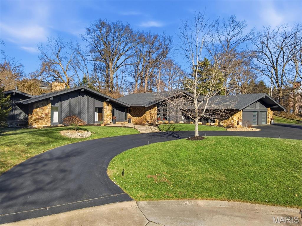 Discover the perfect blend of timeless mid-century architecture and modern luxury at 132 Mystic Meadows Lane in Creve Coeur. Situated on over an acre at the end of a serene cul-de-sac in the highly sought-after Ladue School District, this architecturally significant residence has been thoughtfully and extensively renovated — all while preserving the integrity, character, and unmistakable vibe of the original design.

Inside, a bright, open floor plan unfolds beneath soaring vaulted ceilings, maintaining the home’s iconic architectural lines while enhancing functionality for today’s lifestyle. New finishes and refined updates complement — rather than compete with — the home’s mid-century roots. The living room is anchored by a beautiful wood-burning fireplace, creating a warm and inviting focal point that honors the home’s original character.

The kitchen is a true centerpiece, featuring exquisite African Teak cabinetry that introduces warmth, richness, and texture. This striking material carries into the pantry and primary suite, creating a cohesive and design-forward aesthetic throughout the home.

The walk-out primary suite serves as a private retreat, offering direct access to the outdoors along with a spacious sitting room anchored by its own fireplace. A beautifully designed dressing room and a spa-inspired en suite bath — complete with steam shower, soaking tub, and double vanities — elevate the space into a true sanctuary.

Three additional spacious bedrooms are thoughtfully positioned, along with a dedicated office providing a quiet and functional work-from-home space. A well-designed mudroom area just off the garage entry adds everyday practicality, and an additional half-bath includes a built-in dog wash for added convenience.

The home’s layout wraps seamlessly around a private, landscaped backyard oasis with a pool, offering effortless indoor-outdoor living and ideal spaces for entertaining or quiet relaxation.

The finished lower level expands the living experience with slate floors, a wet bar, sauna, full bath, and a hidden room tucked behind a custom bookcase. With walk-out access to the backyard, dual laundry areas on the main and lower levels, a large circular driveway, and a three-car garage, the home balances architectural significance with modern comfort.

More than a residence, this is a rare opportunity to own a beautifully preserved and reimagined mid-century home in one of Creve Coeur’s most coveted settings.