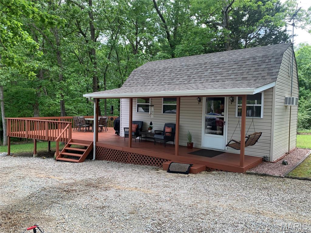 Gated lake community just 45 mins south of St. Louis! Looking to escape for a weekend getaway or full-time residence, this charming one- bedroom, one-bath, full kitchen cabin offers the ideal blend of relaxation, recreation, and community living. Situated on 4 level lots totaling over an acre corner lot, this well maintained property provides plenty of room to spread out and enjoy the outdoors. Spend your evening relaxing on the spacious deck, hosting BBQ's, gatherings and making unforgettable memories with family and friends. There's ample parking for boats, side-by-sides, razors and guest. The property also features 2 RV hookups, complete with electric, well water and holding tank- perfect for future building add on's.  Need extra storage or room to expand, you'll love the outbuilding that could easily be converted into additional living space, along with a convenient carport with a small workshop /storage area. The  gated lake community itself offers over 400 acres of enjoyment including fishing lakes, beach, boat slips, playground, recreational areas and a community pool. More than just a neighborhood, this gated community is a place where friendships are made and lifelong memories begin. At this price point, opportunities like this rarely come along.. Start living the lake life TODAY!!