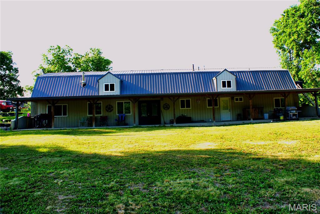 Welcome to your private retreat, where country living meets modern comfort on 38 +/-beautiful acres of mature timber. This stunning barndominium-style home blends rustic charm with contemporary finishes, creating a warm and inviting atmosphere perfect for everyday living or weekend escapes. Step inside to a spacious open-concept floor plan featuring soaring ceilings, abundant natural light, and custom touches throughout. The thoughtfully designed kitchen offers modern cabinetry, rustic accents, updated appliances, and ample space for entertaining family and friends. A cozy loft overlooks the main living area, adding character and versatility to the home. Outside, you'll find a large covered porch that invites you to relax and take in the peaceful surroundings. The property's centerpiece is a beautiful 14-foot-deep pond complete with a filtration system and dock area, providing the perfect setting for fishing, recreation, or simply enjoying quiet evenings by the water. Surrounded by mature hardwoods, the 38-acre tract offers exceptional privacy and outstanding opportunities for hunting, hiking, ATV riding, or exploring nature right outside your door. Functional laundry and storage areas add convenience, while the home's rustic-modern design delivers comfort and style throughout. Whether you're searching for a full-time residence, hunting property, recreational getaway, or family retreat, this remarkable property offers the perfect combination of modern amenities, natural beauty, and country charm.
